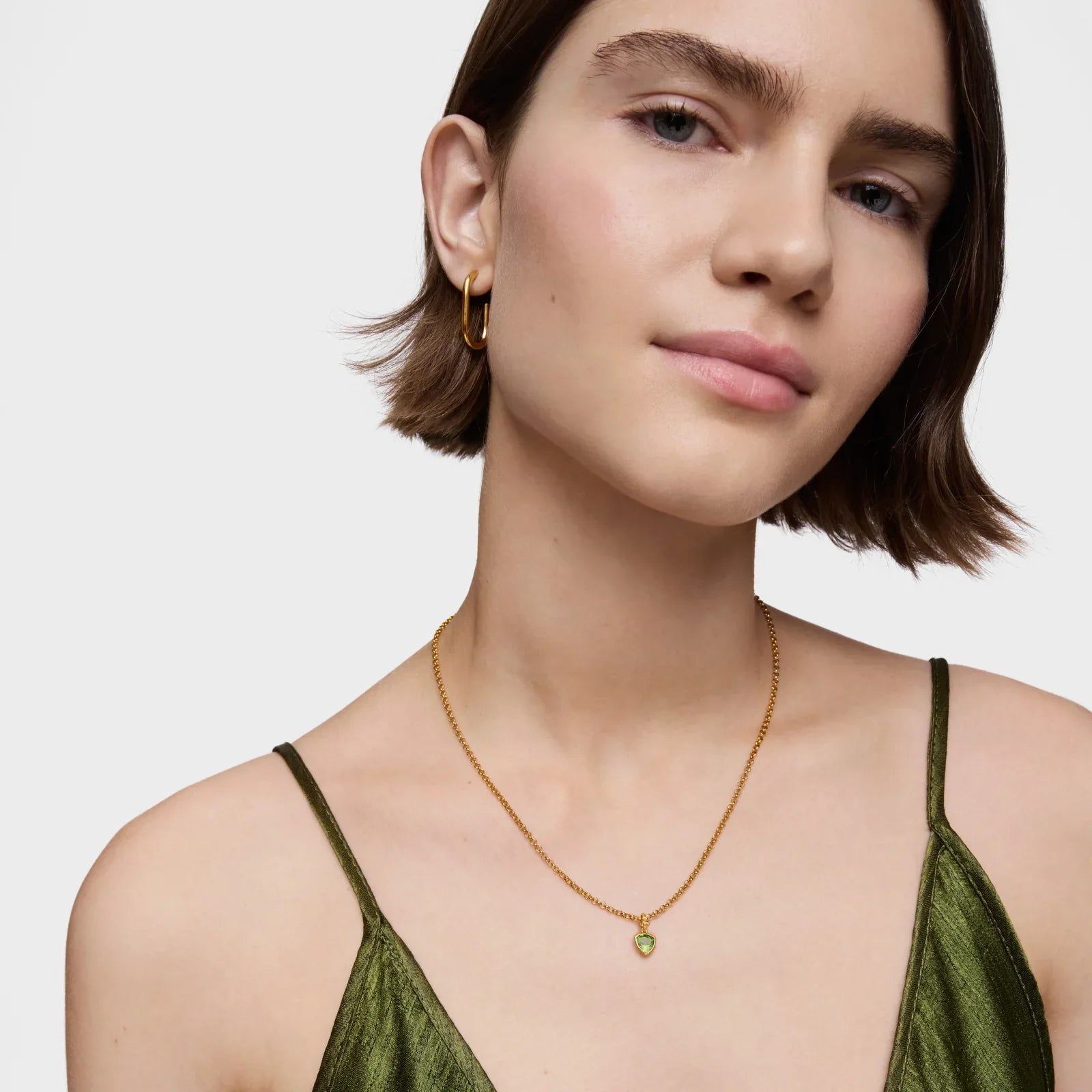 דוגמנית עונדת שרשרת זהב עם תליון ירוק ועגילי חישוק, CHOZEN תכשיטים יוקרתיים