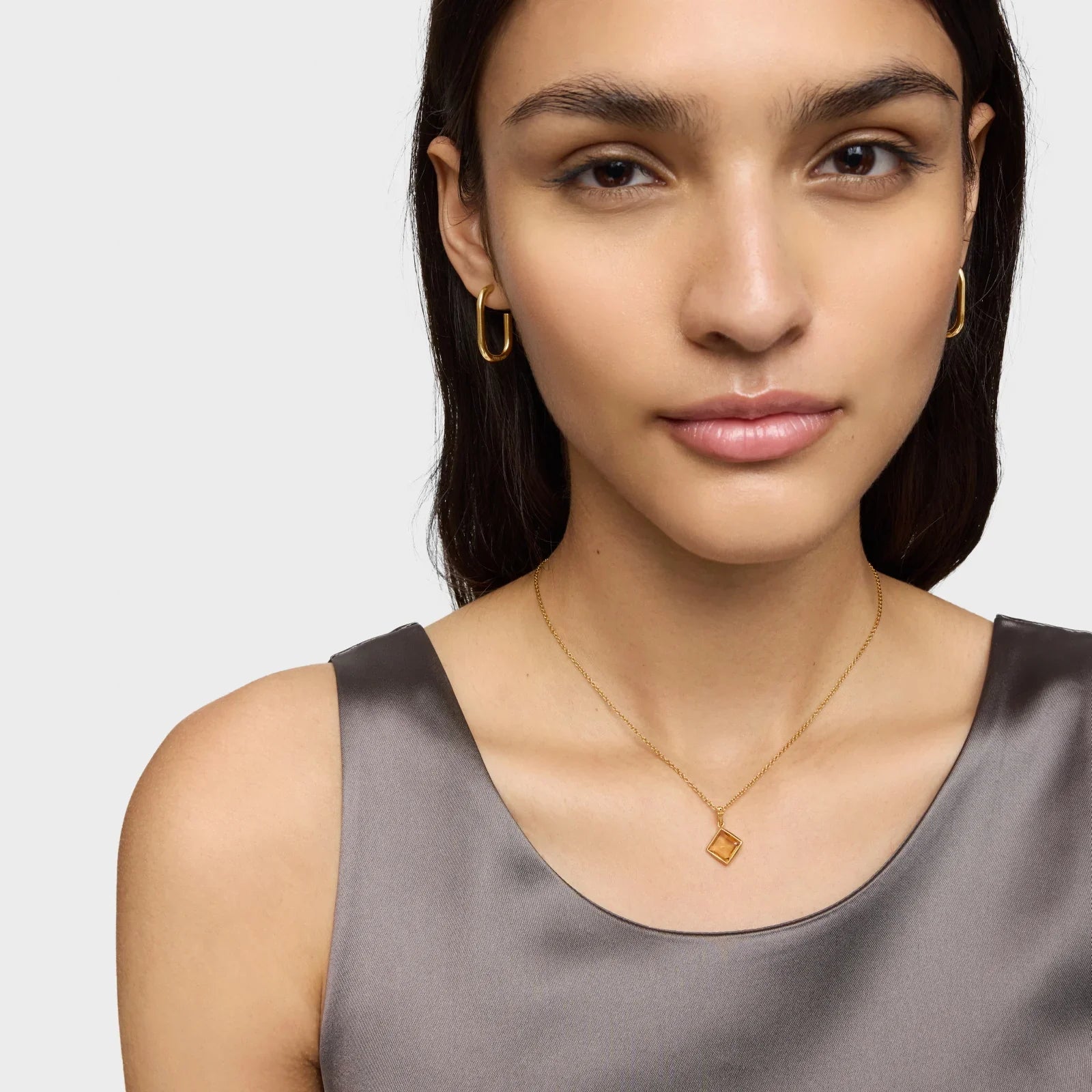 דוגמנית עונדת עגילי זהב ושרשרת זהב עדינה, צילום תקריב לאתר CHOZEN