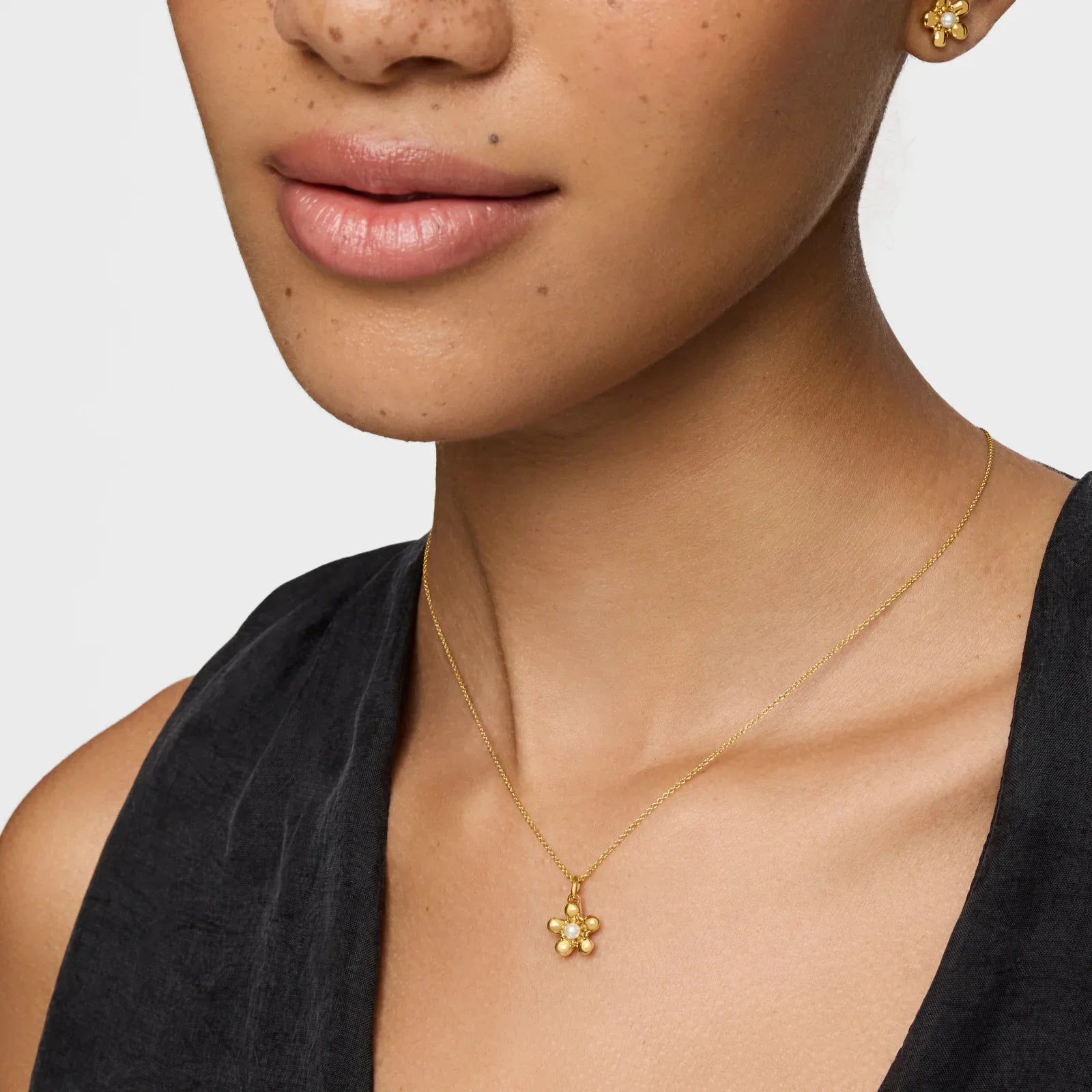 אישה עונדת שרשרת זהב ותליון פרח, עגיל פרחונים, תכשיטים יוקרתיים CHOZEN