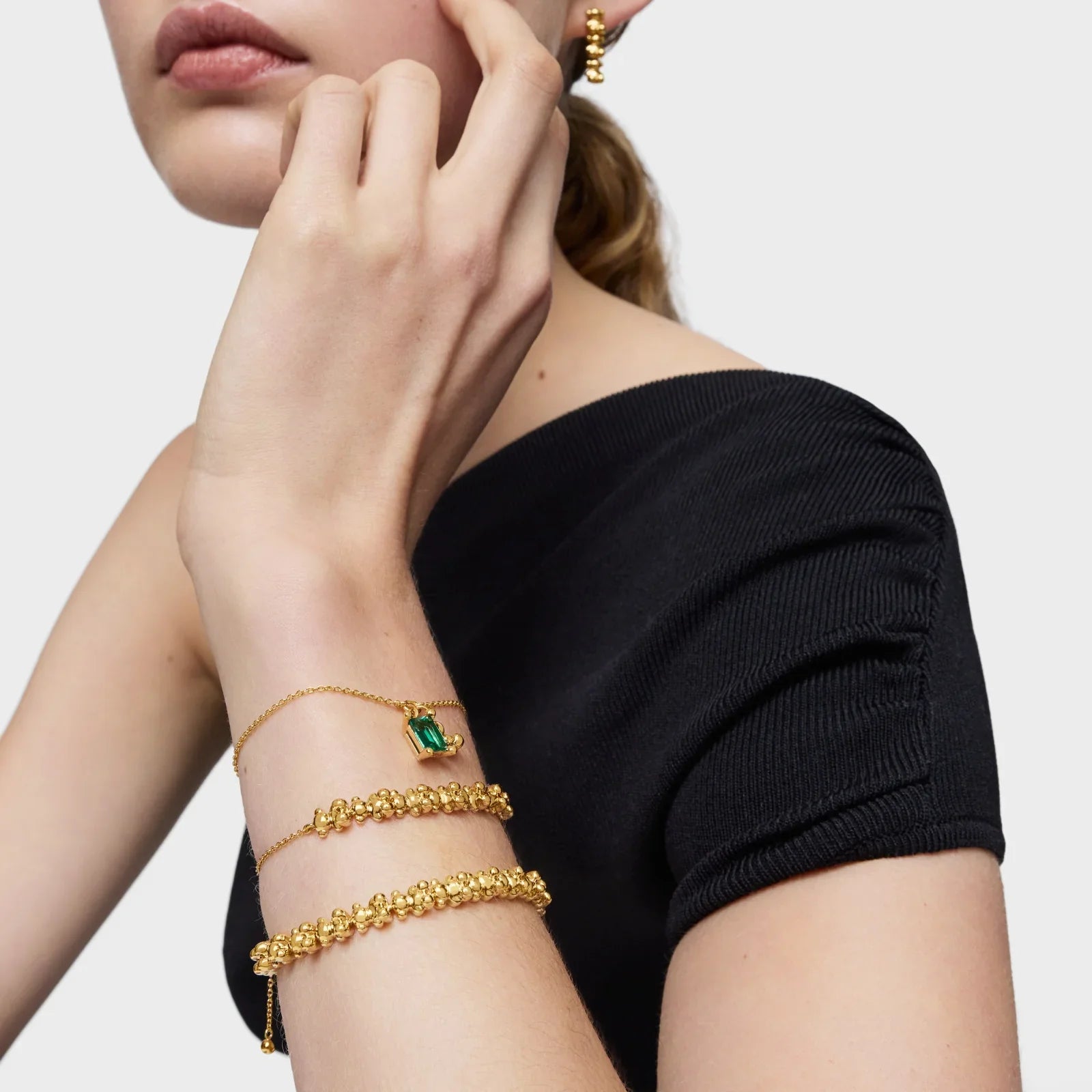 תכשיטי זהב יוקרתיים עם אבן ירוקה על דוגמנית בחולצה שחורה, CHOZEN מותגים מובילים