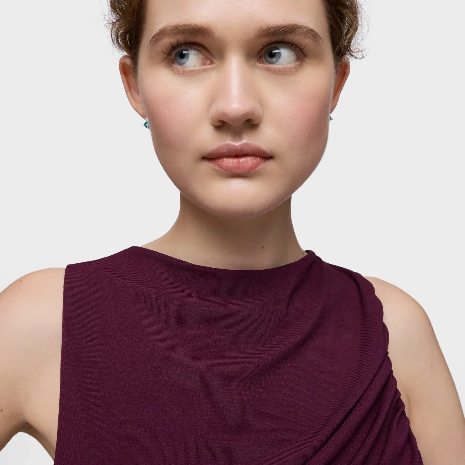 אישה צעירה עם עגילים ותלבושת בורדו, צילום תדמית לאתר CHOZEN