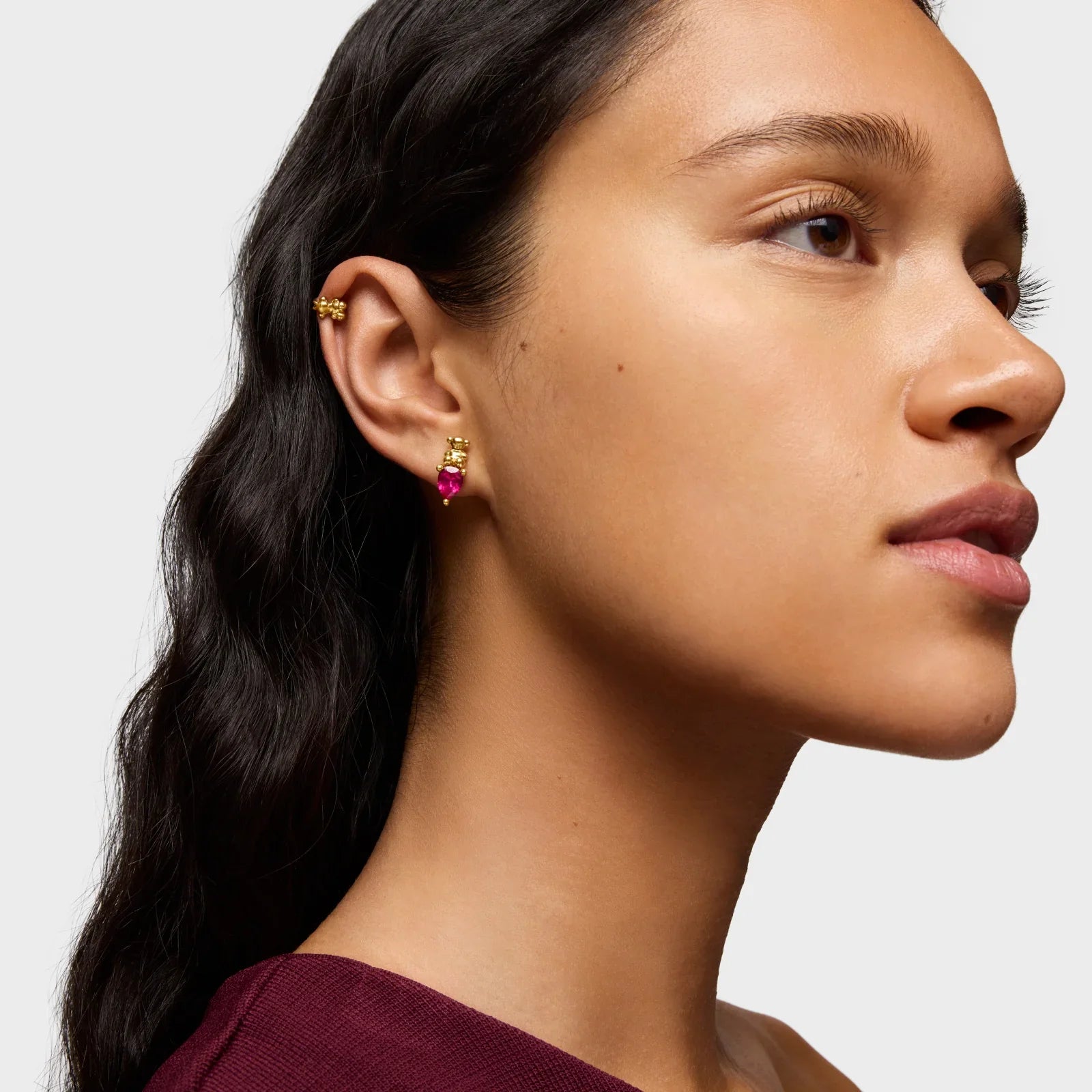 דוגמנית עונדת עגילי זהב עם אבני חן אדומות CHOZEN, צילום תקריב אופנתי