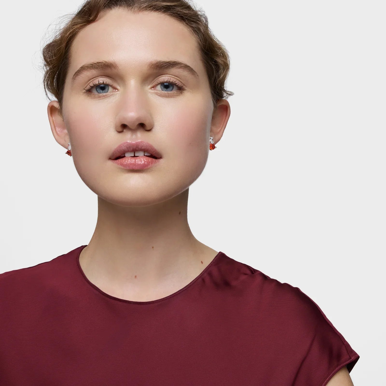 אישה עם עגילים אדומים וחולצה בורגונדי, קמפיין תכשיטים CHOZEN מותגים מובילים