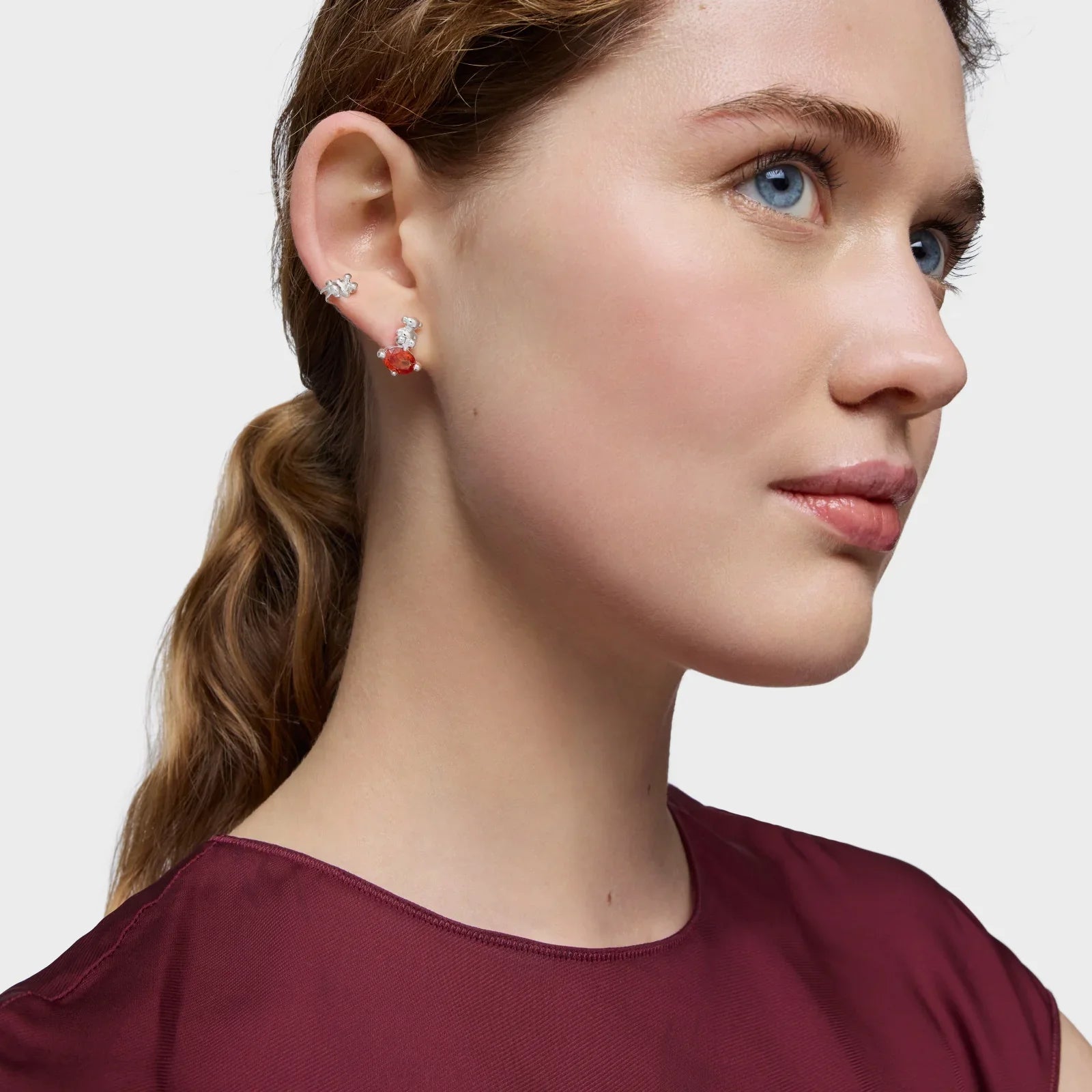 דוגמנית עונדת עגילים מעוצבים, רקע לבן, אופנה יוקרתית CHOZEN