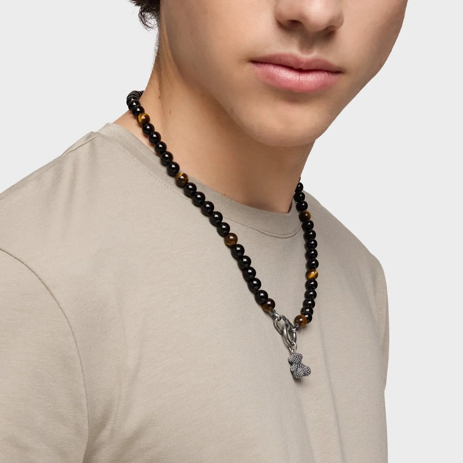 גבר צעיר עונד שרשרת חרוזים שחורה עם תליון דוב כסף, אופנת גברים CHOZEN