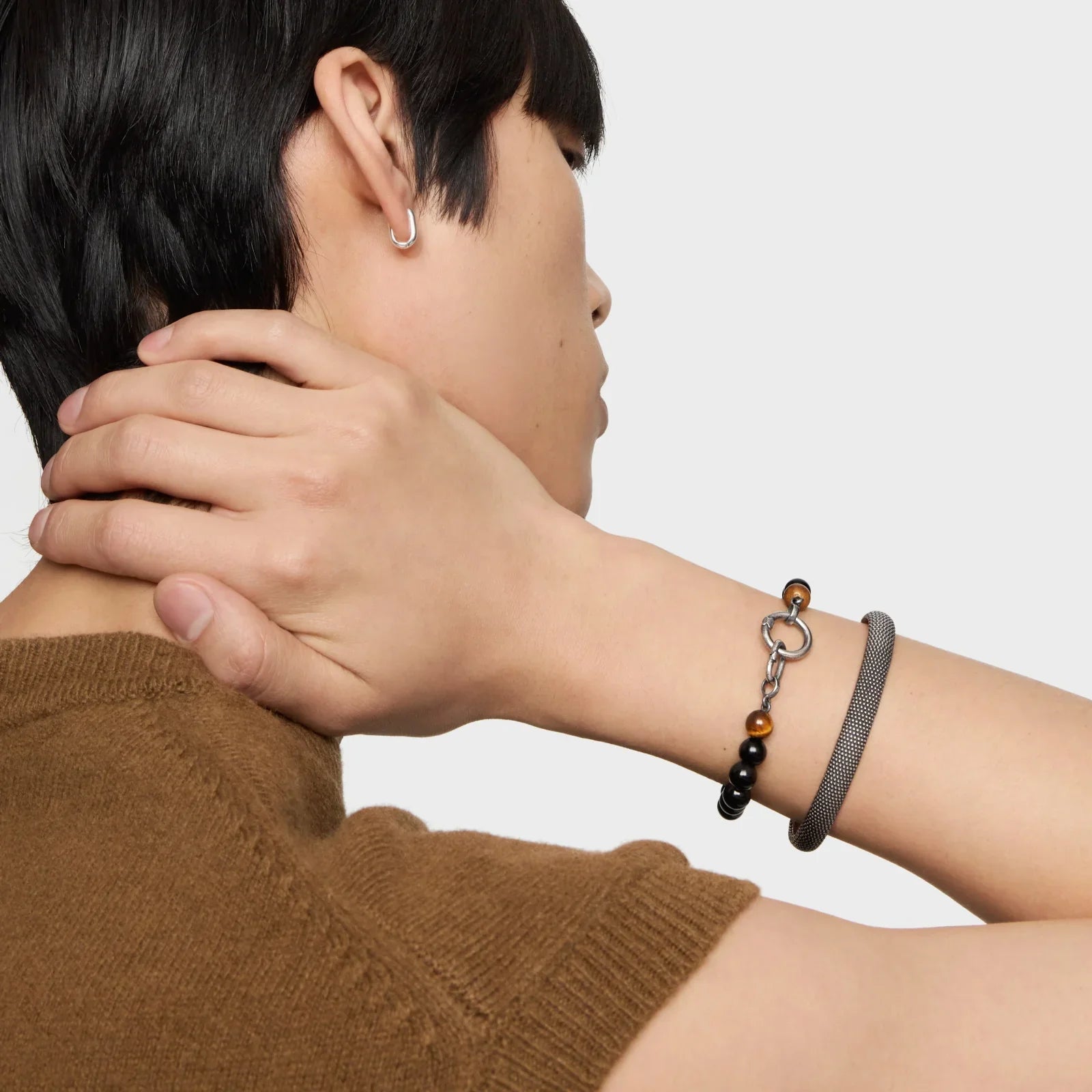 יד גבר עונדת צמידים אופנתיים ותכשיט כסף, צילום תקריב לחנות CHOZEN