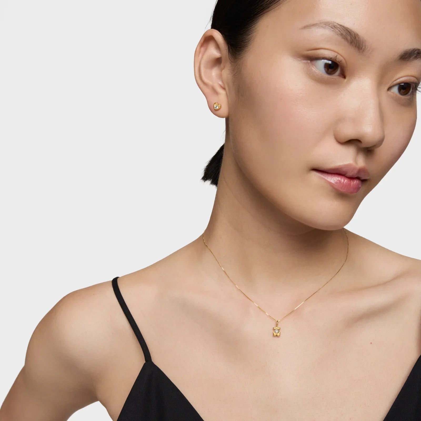 דוגמנית עם עגילי זהב עדינים ושרשרת זהב עם תליון, צילום תכשיטים CHOZEN