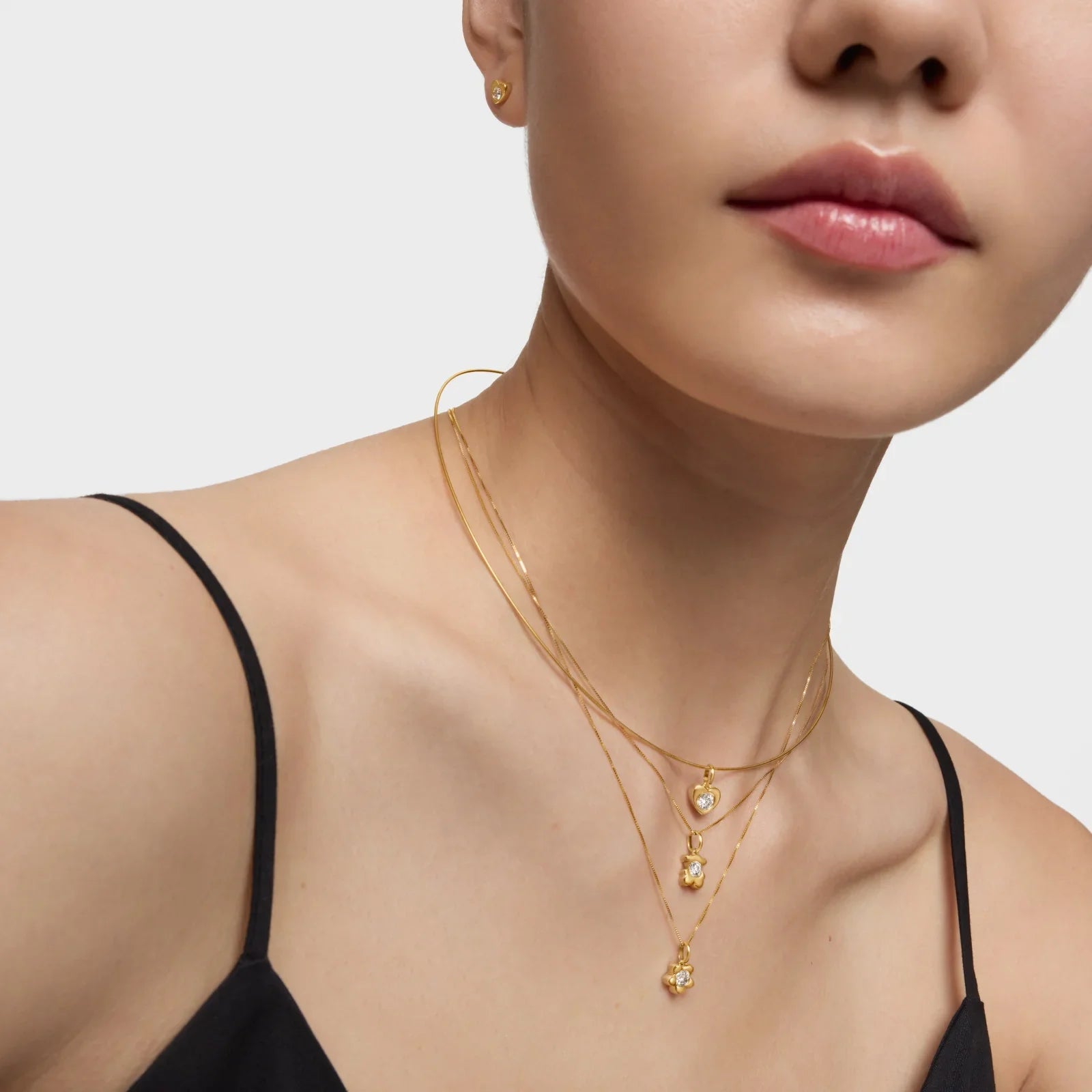 דוגמנית עם שרשראות זהב דקיקות ועגיל זהב, מתוך קולקציית תכשיטים יוקרתית באתר CHOZEN