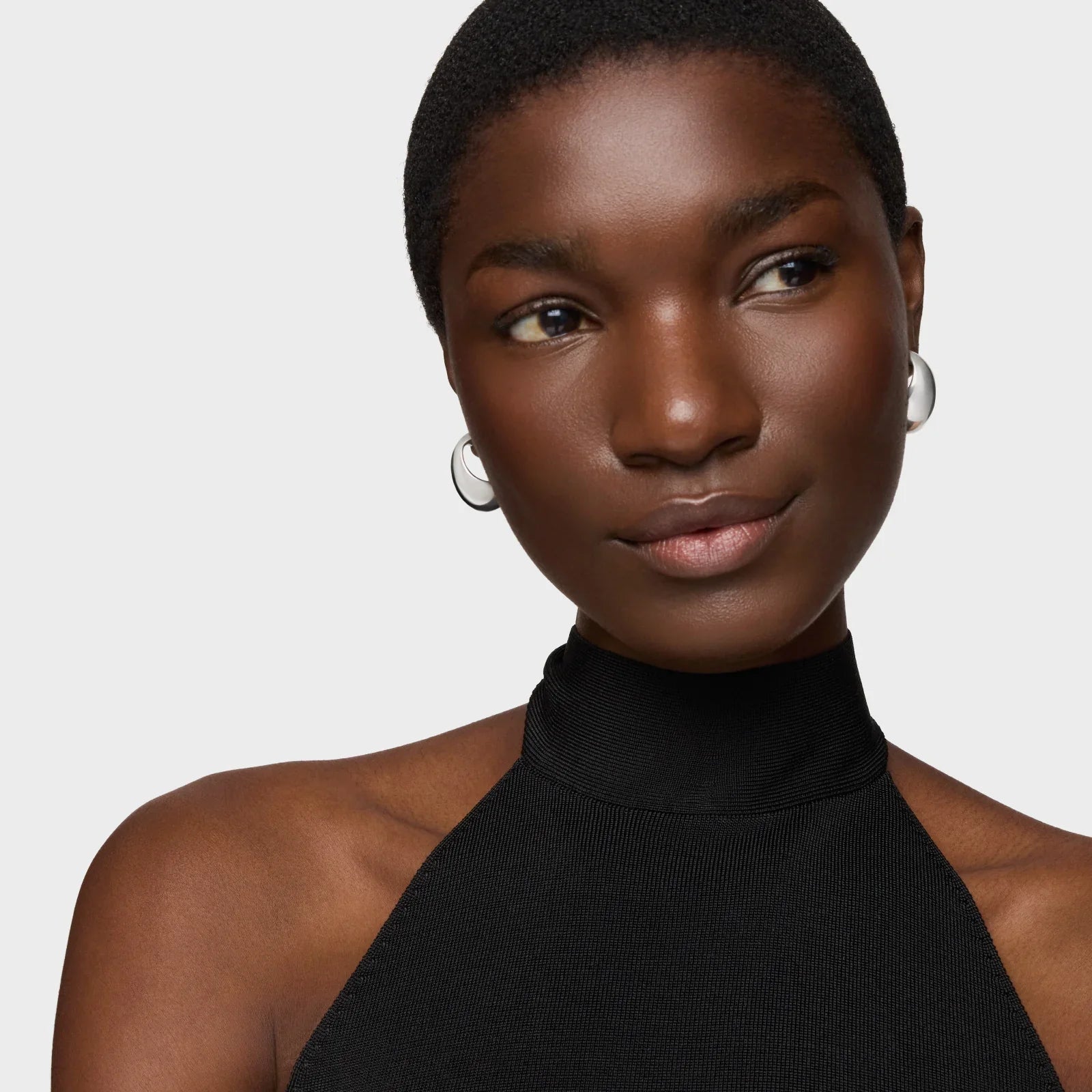 דוגמנית עם גופיית צווארון שחורה ועגילי כסף, צילום אופנה לאתר CHOZEN