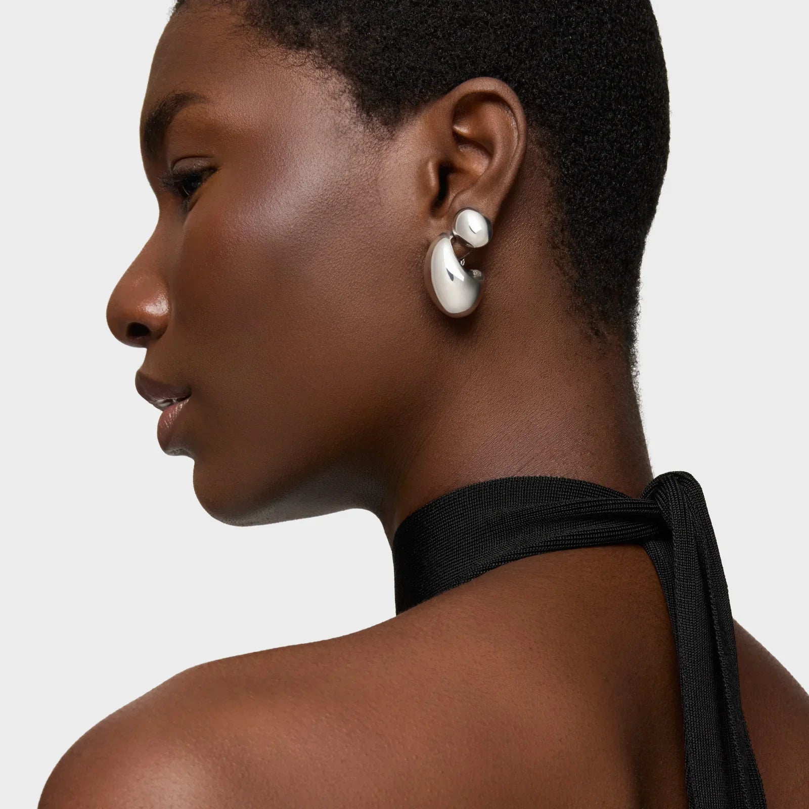 דוגמנית עם עגילי כסף מעוצבים, קצה צעיף שחור, צילום סטודיו לחנות CHOZEN