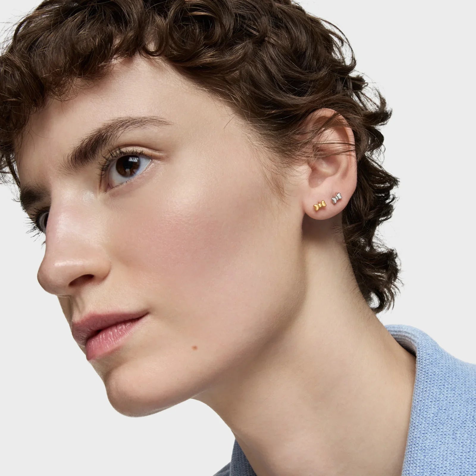 דוגמנית עונדת עגילים עדינים מזהב וכסף, צילום תקריב, CHOZEN מותגים מובילים