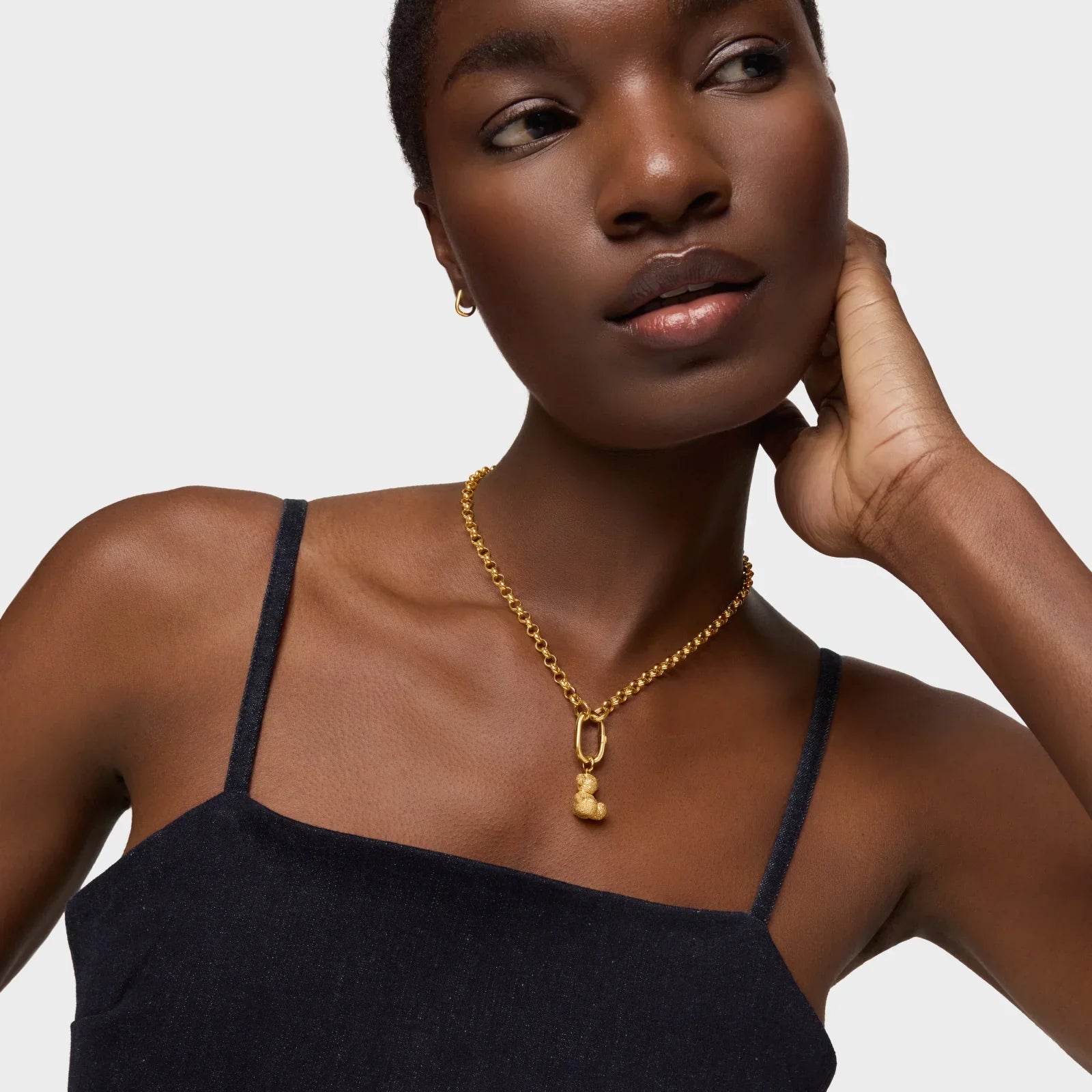 אישה לובשת שרשרת זהב מעוצבת ובגד שחור יוקרתי, CHOZEN מותגים מובילים