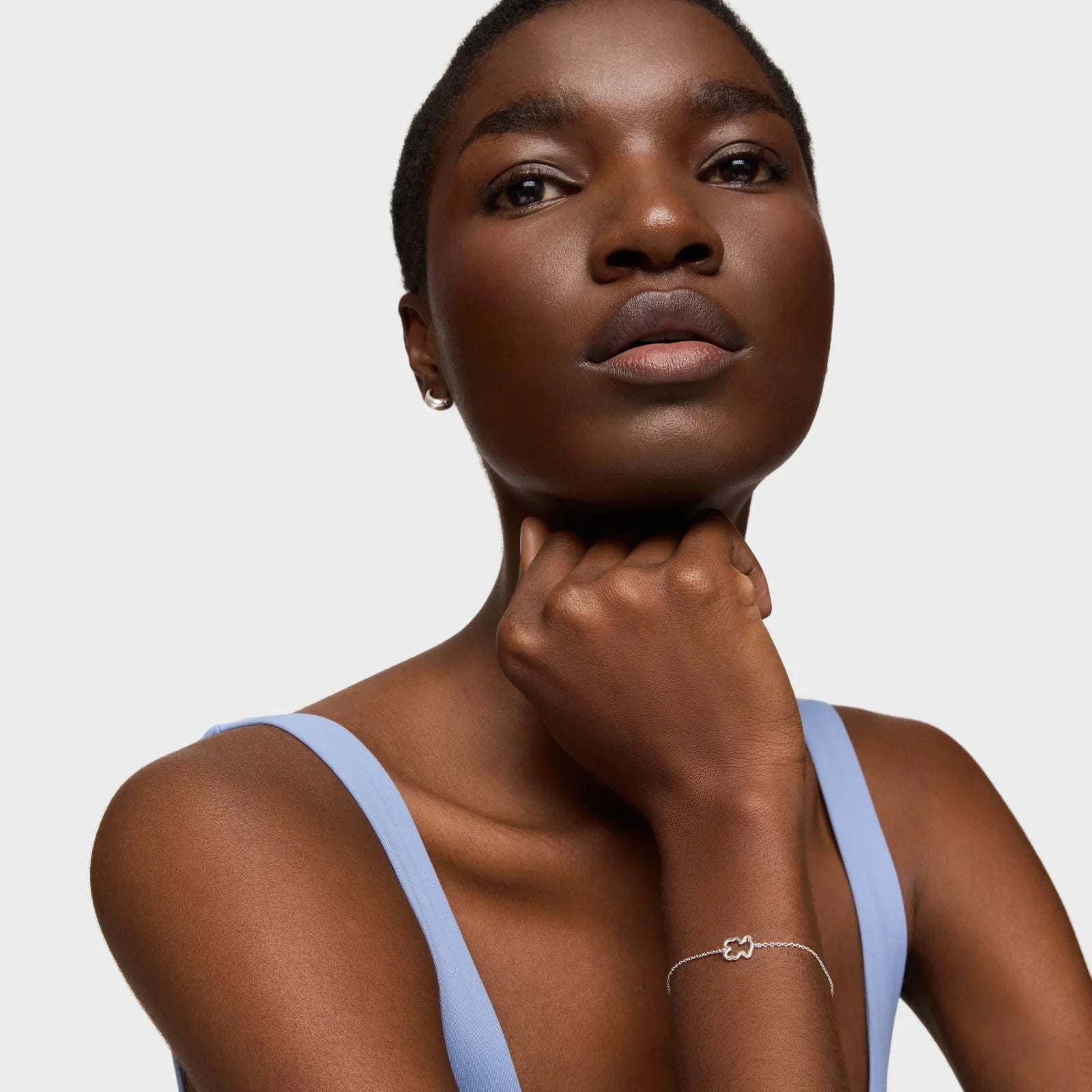 דוגמנית עם גופייה כחולה וצמיד כסף עדין, תכשיטים אופנתיים מבית CHOZEN