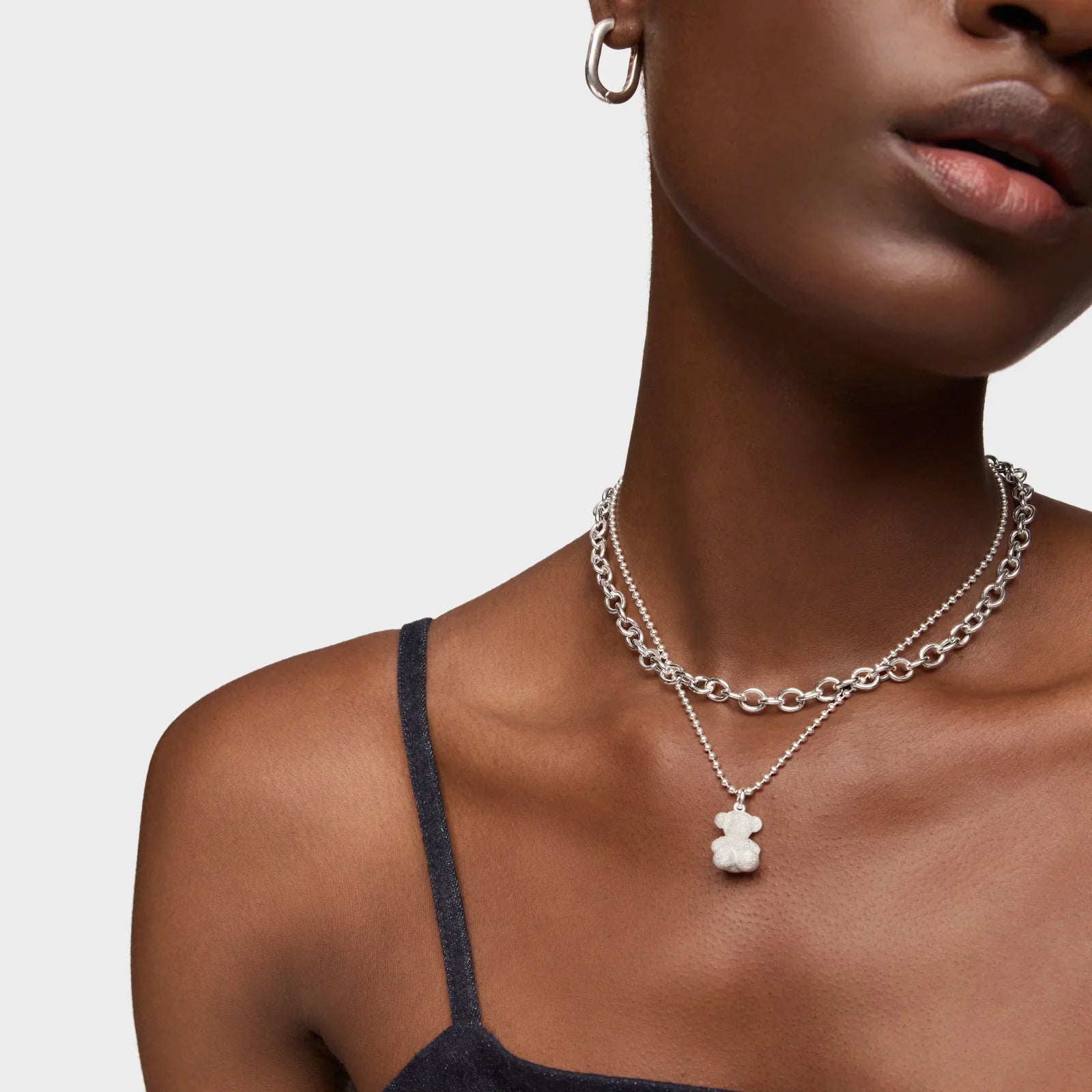 שרשרת כסף עם תליון דוב ושכבת שרשרת נוספת, על רקע חלק, מבית CHOZEN קבוצת אלפא