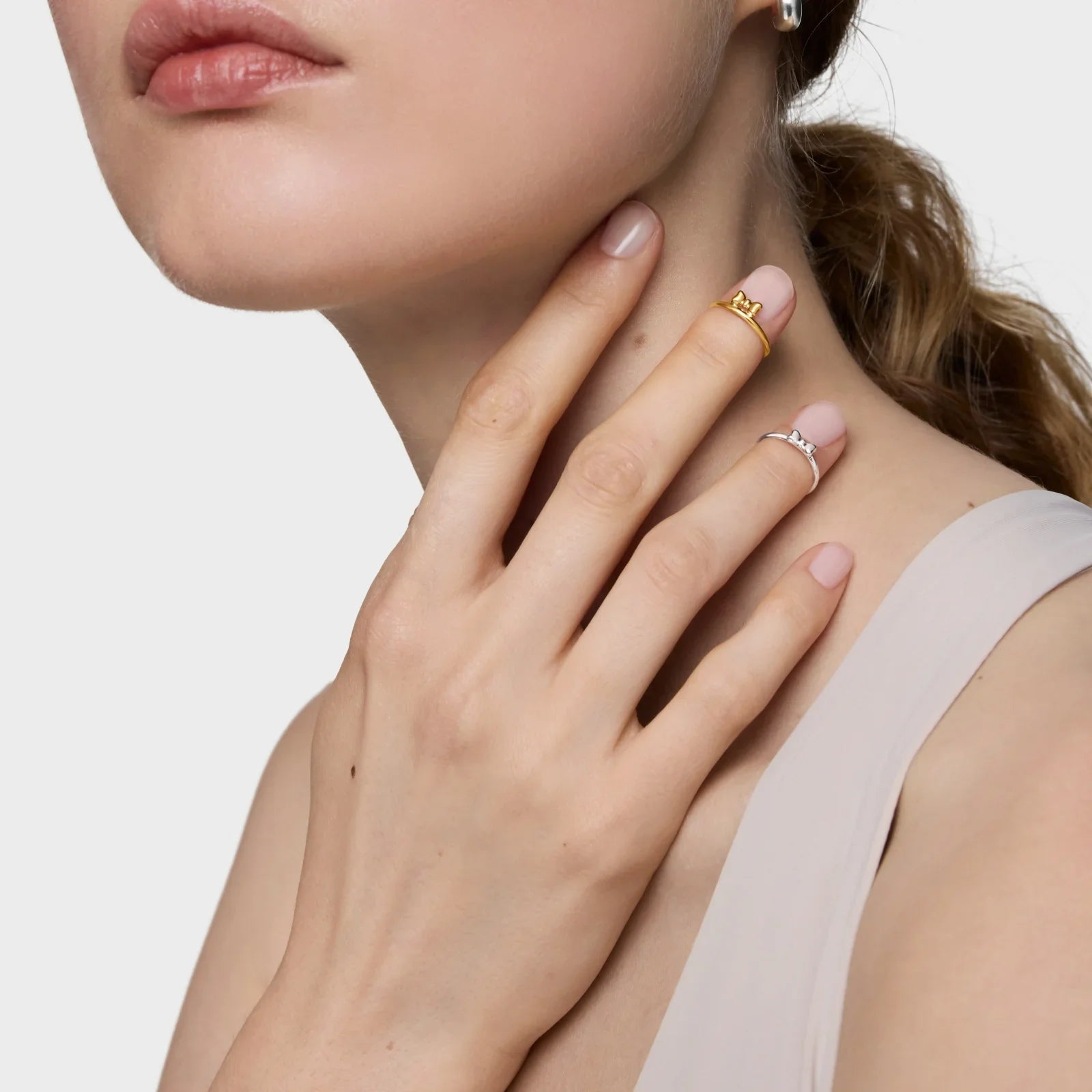 אישה עונדת טבעות זהב וכסף בעיצוב כתרים, צילום תכשיטים יוקרתיים CHOZEN