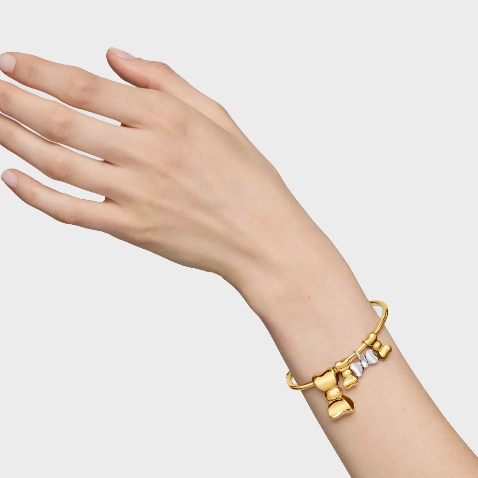 צמיד זהב מעוצב עם תליונים בצורת פפיונים על פרק כף היד, צילום שיווקי מבית CHOZEN