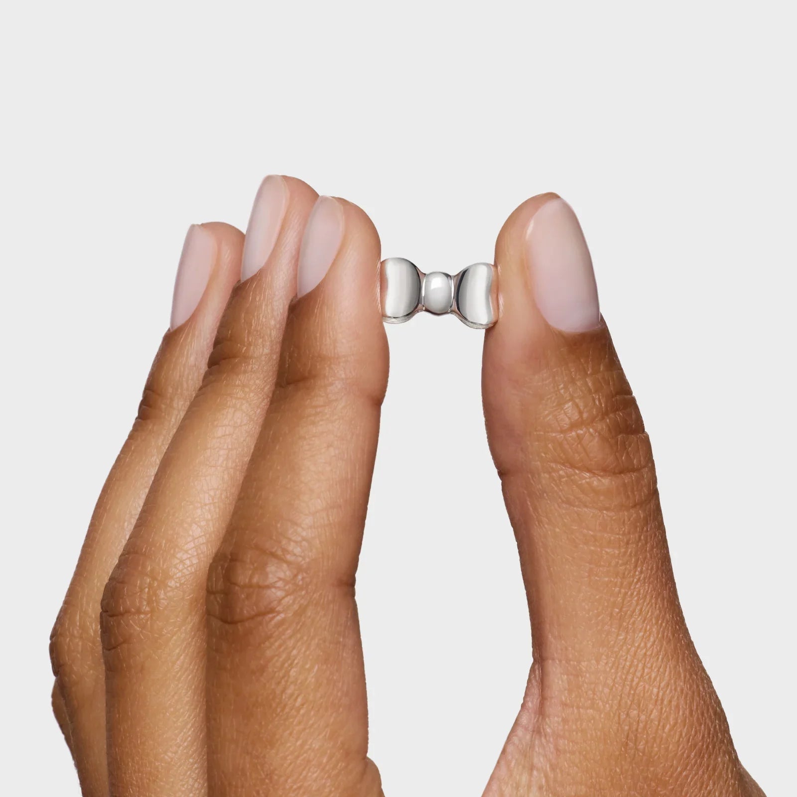 אישה מחזיקה עגיל כסף קטן בעיצוב מודרני, תכשיטי CHOZEN קבוצת אלפא