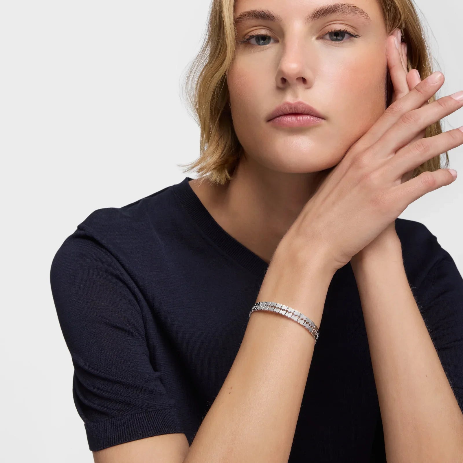 אישה לובשת חולצה כהה, עונדת צמיד כסף יוקרתי, תכשיטים מהמותגים המובילים ב-CHOZEN