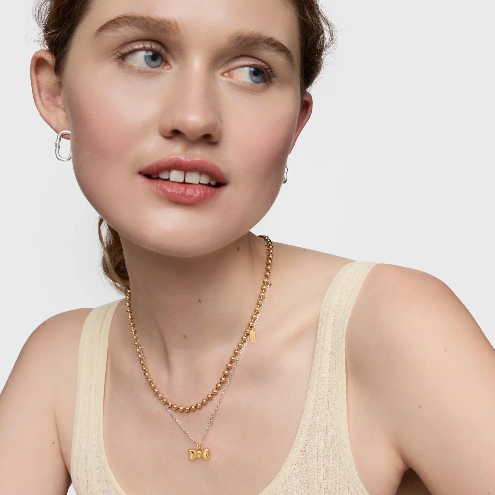 דוגמנית עונדת שרשראות זהב עדינות ועגילי כסף, תכשיטי אופנה באתר CHOZEN