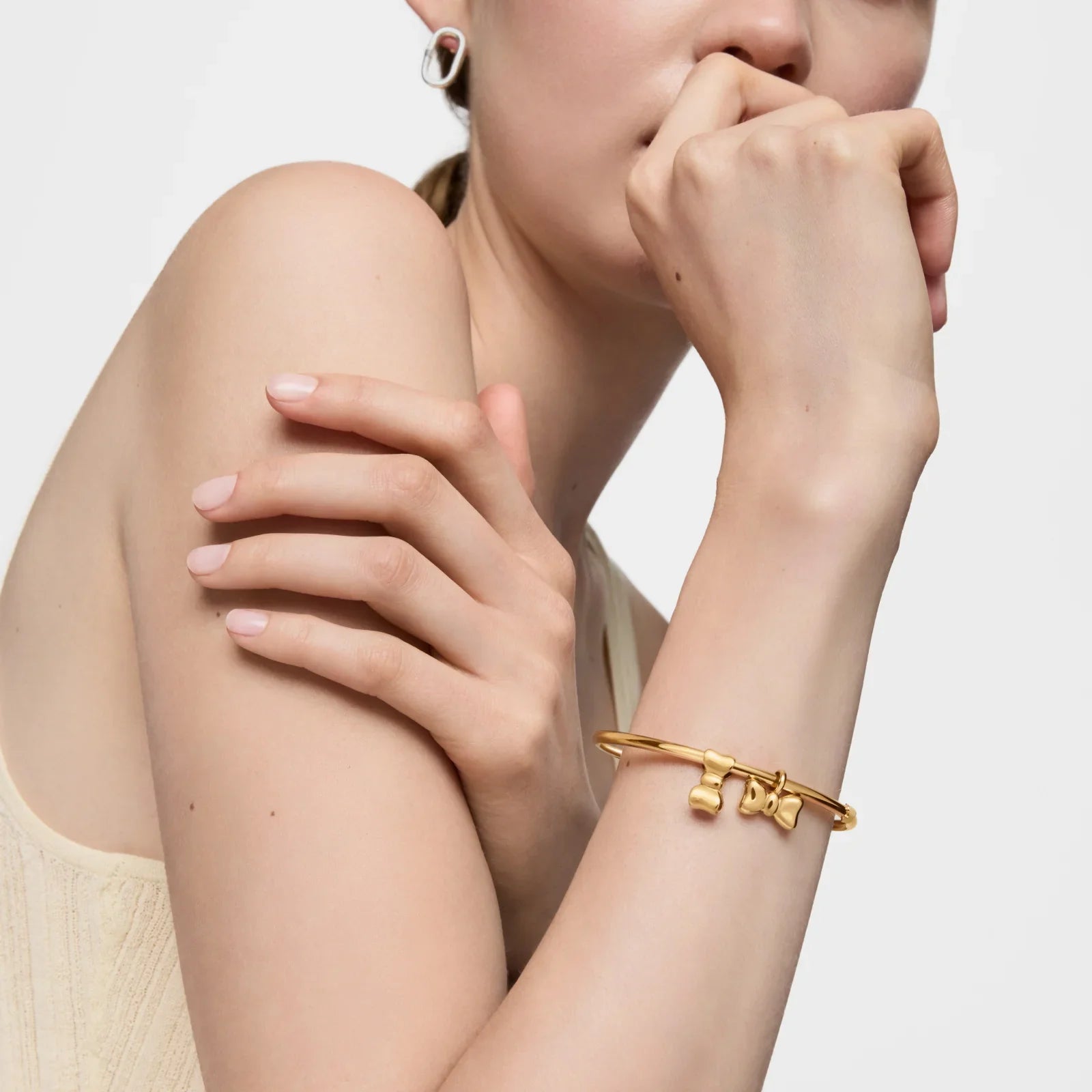 אישה עונדת צמיד זהב בעיצוב ייחודי, תכשיט אופנה יוקרתי מבית CHOZEN