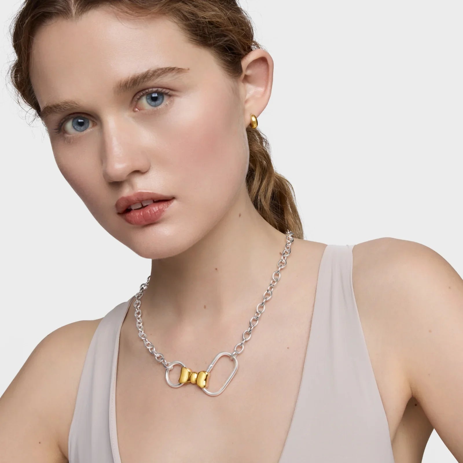 דוגמנית עונדת שרשרת כסף ועגיל זהב, תכשיטים יוקרתיים של מותגים מובילים מקבוצת אלפא
