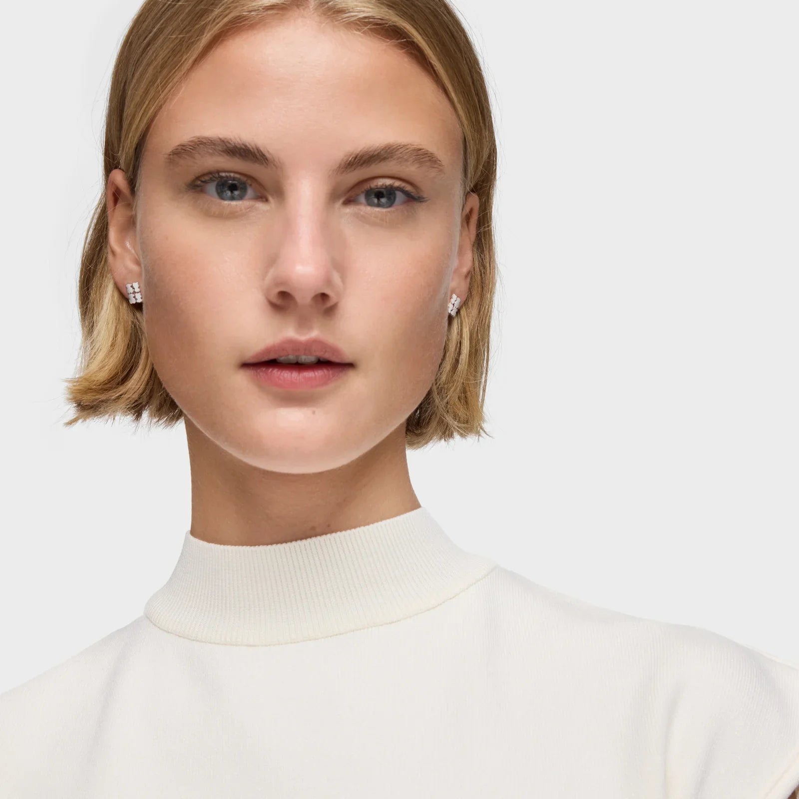 דוגמנית עם חולצה לבנה ועגילי יהלום, צילום קמפיין מותג אופנה CHOZEN