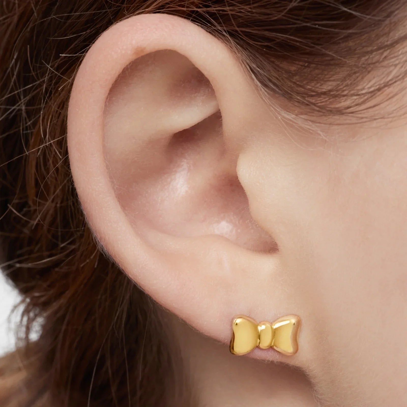 עגיל זהב בצורת סרט מוצג על אוזן, תכשיטים איכותיים מבית CHOZEN