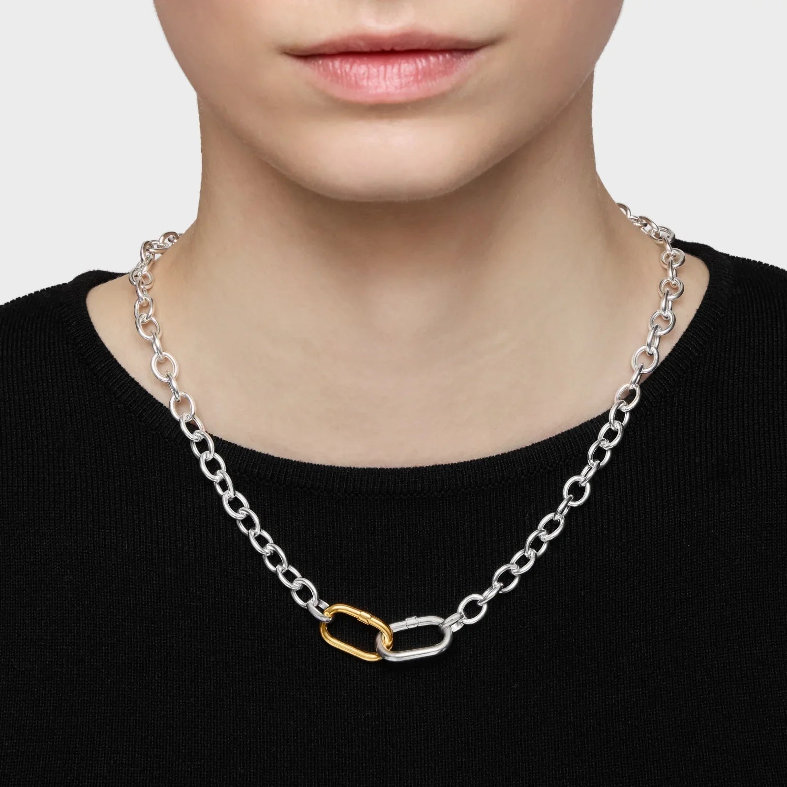 שרשרת כסף בעיצוב לינקים, כולל חוליה מוזהבת, על רקע חולצה שחורה, CHOZEN מותגים מובילים