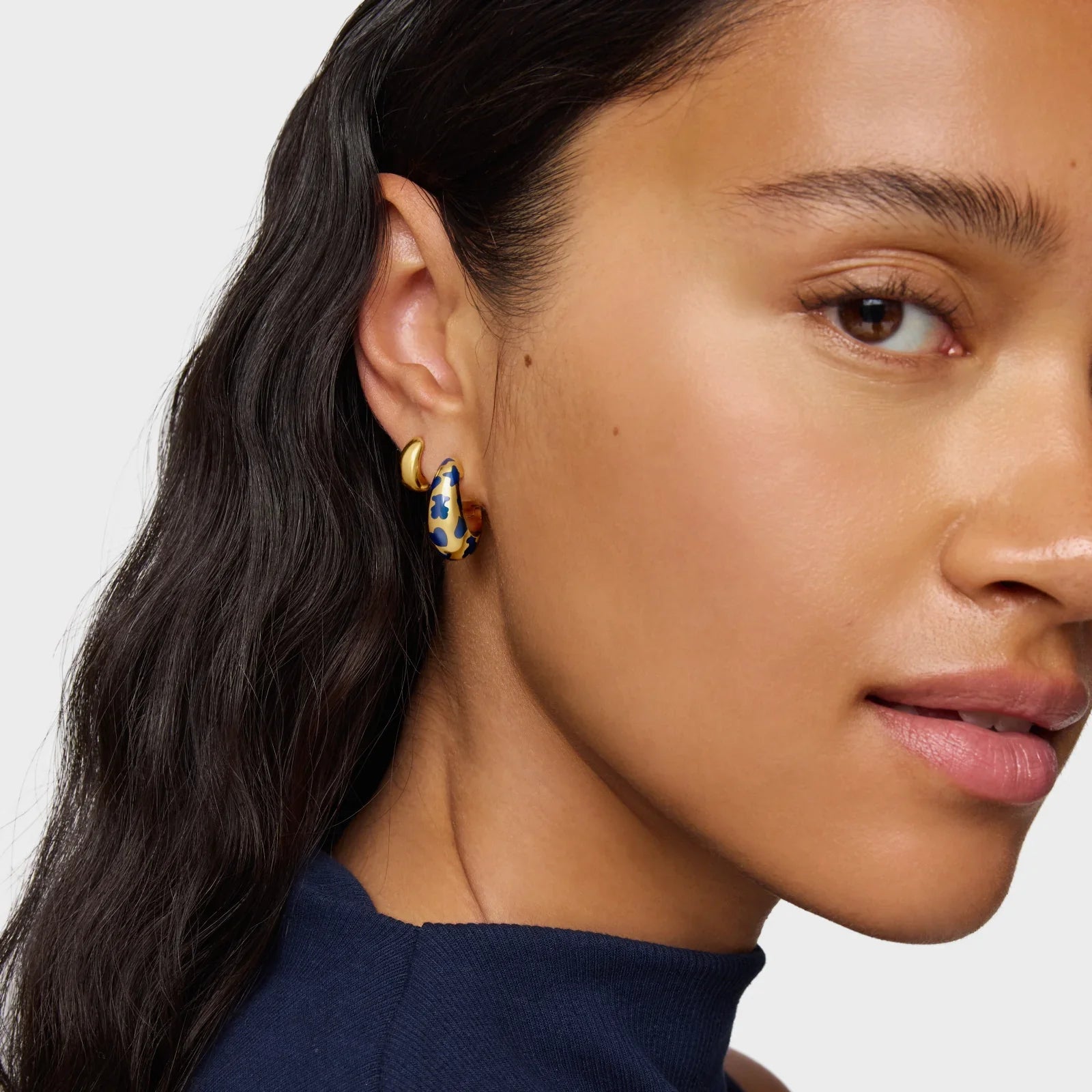 אישה עונדת עגילי חישוק אופנתיים זהב וכחול, תקריב פנים, CHOZEN מותגים מובילים