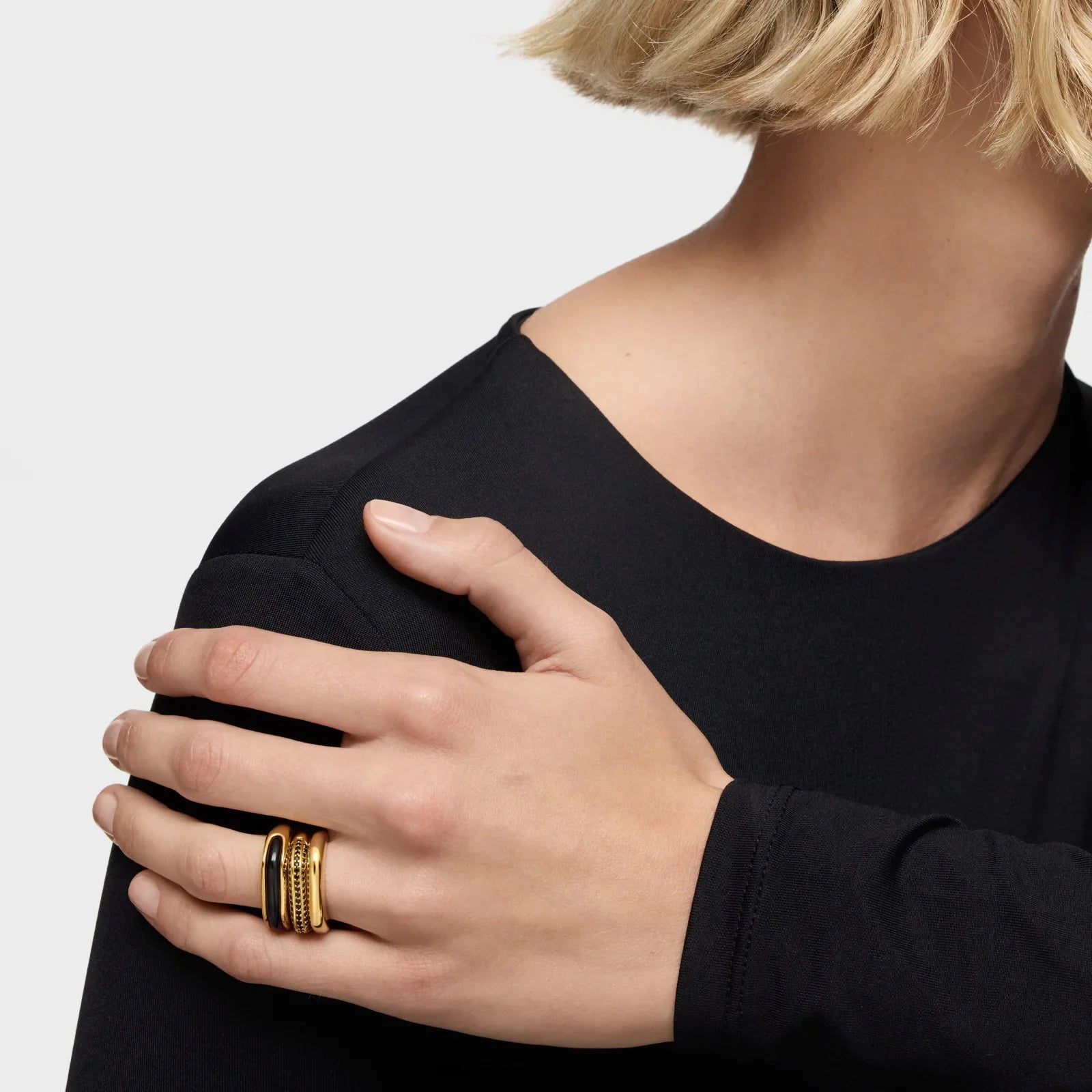 יד של אישה עם טבעות זהב טרנדיות, צילום תקריב, תכשיטים מובילים מבית CHOZEN