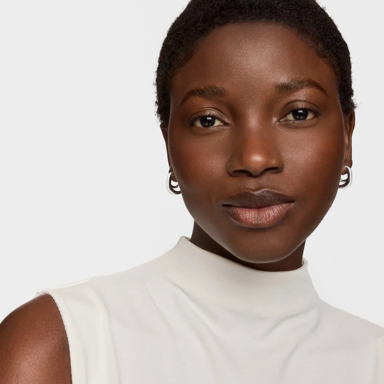 אישה עונדת עגילי כסף, חולצה לבנה, צילום תקריב, CHOZEN מותגים מובילים