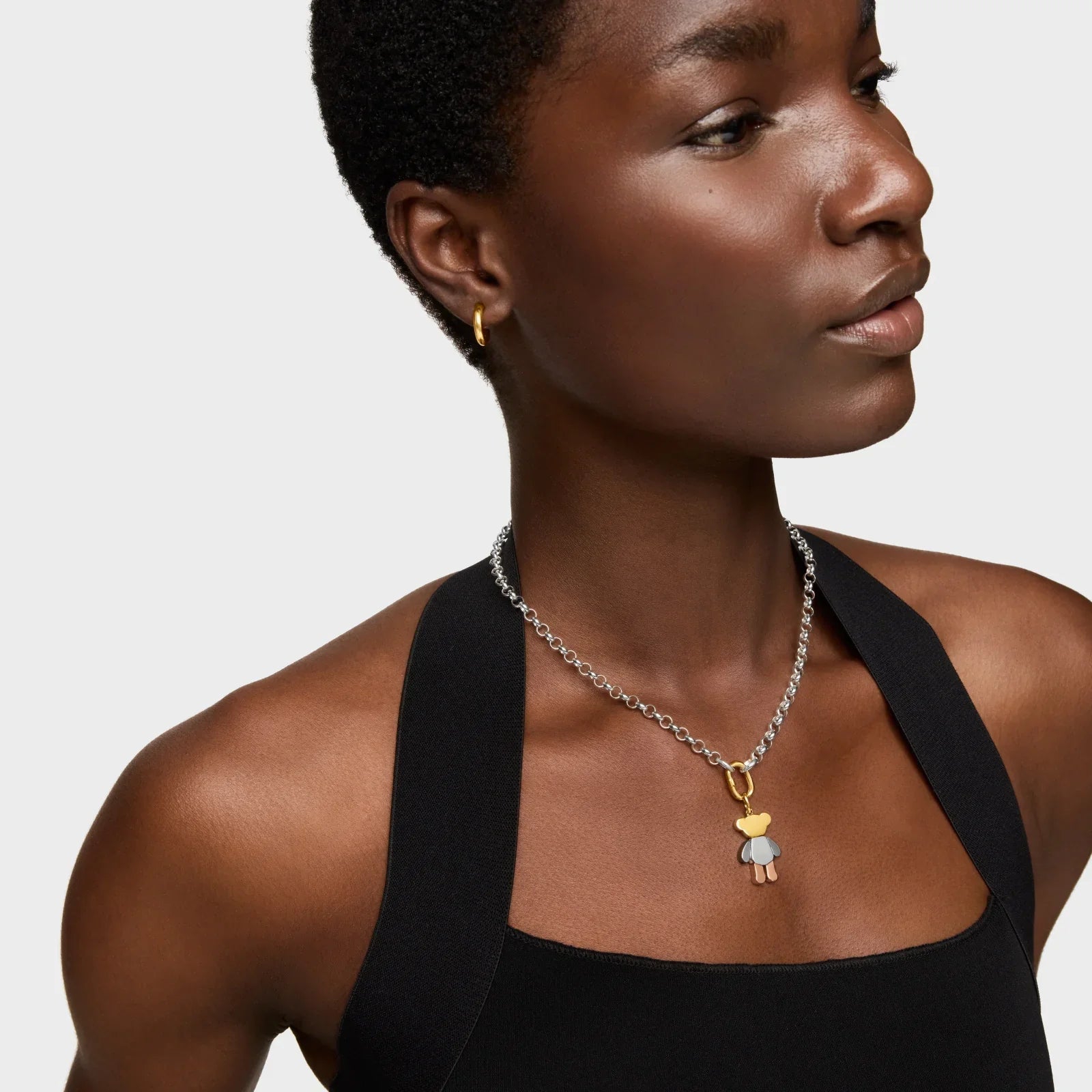 אישה עם שרשרת כסף עם תליון דובי, לובשת שמלה שחורה, צילום אופנה ל-CHOZEN