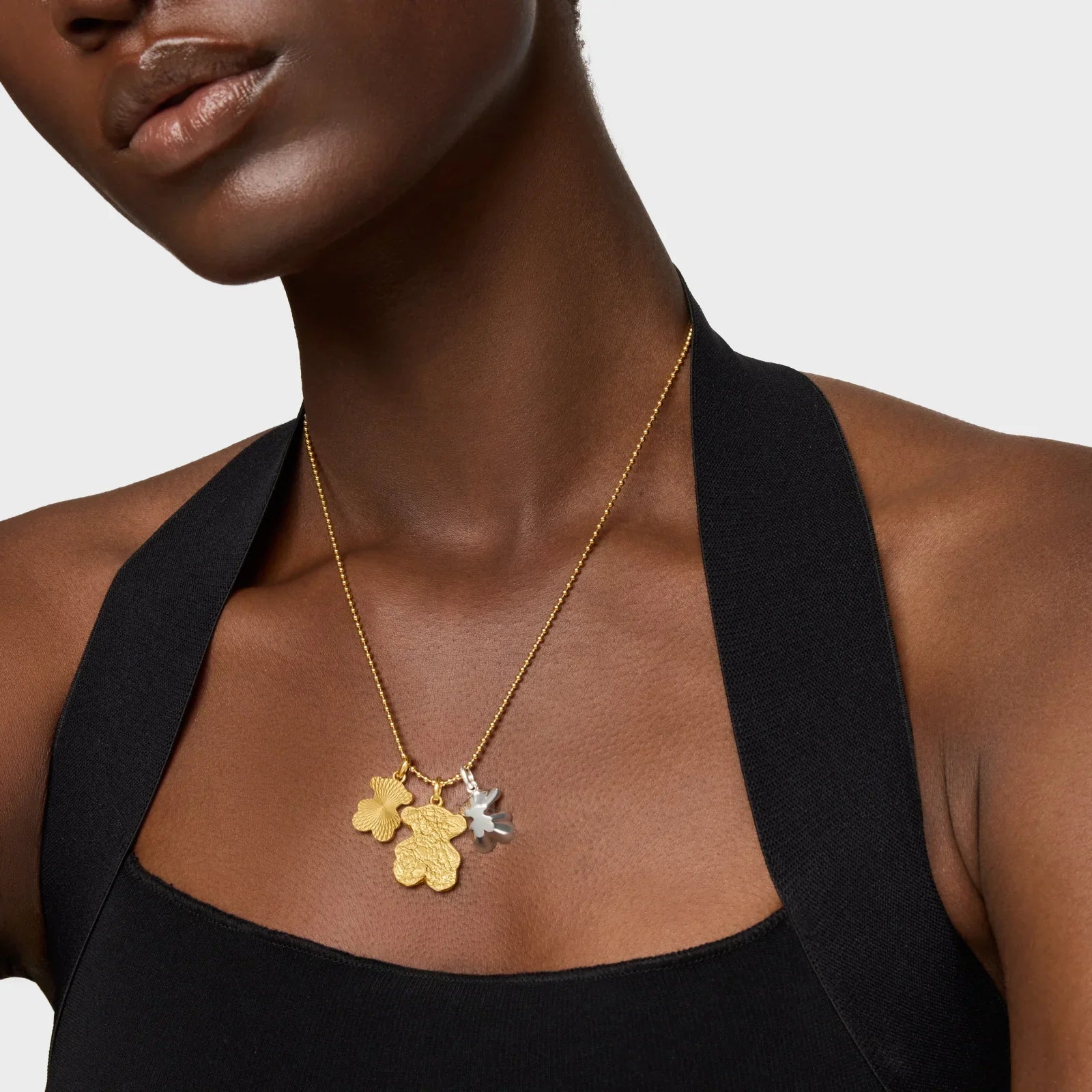 דוגמנית עם שרשרת זהב ותליונים מעוצבים בצורת פרחים, צילום תכשיטים לאתר CHOZEN