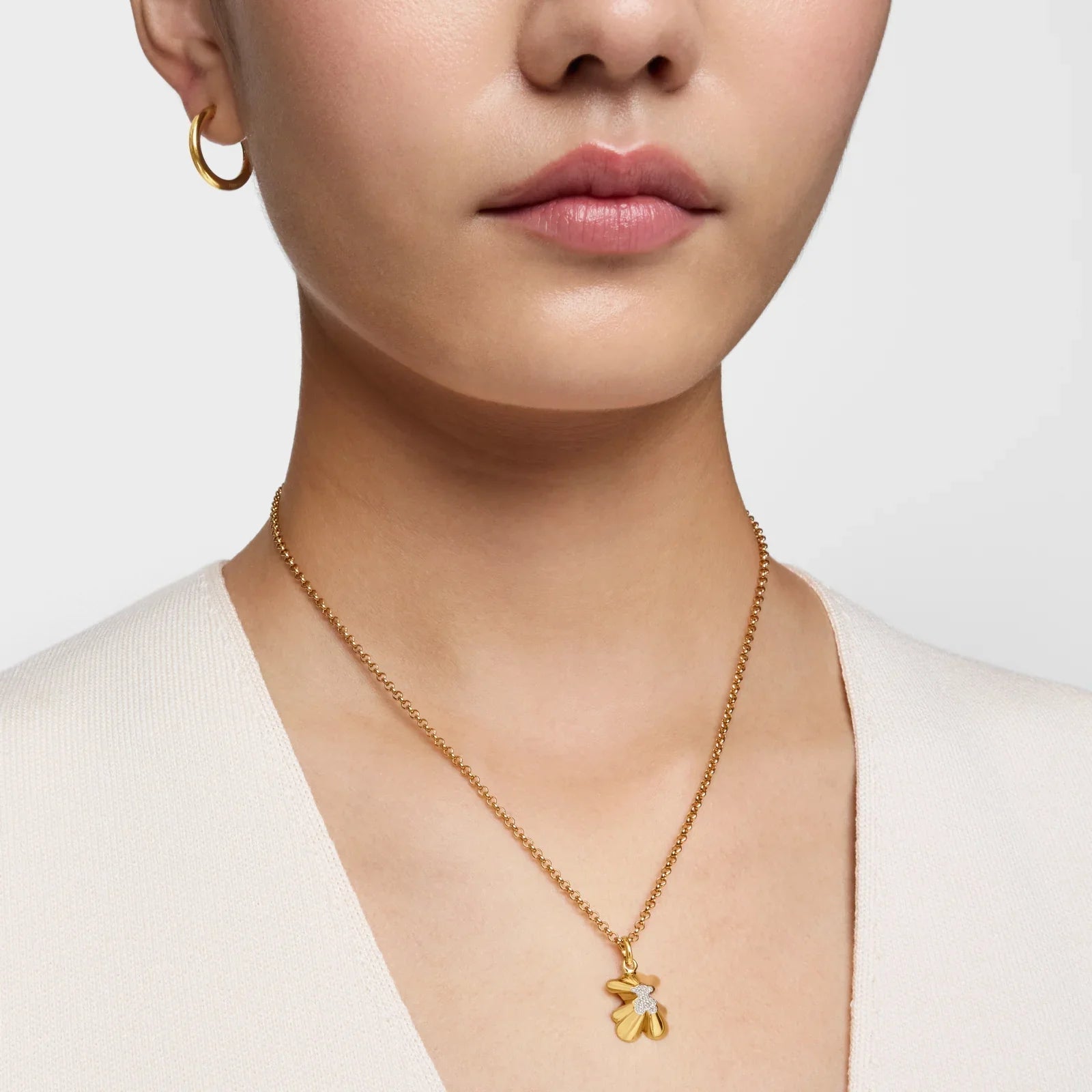 שרשרת זהב עדינה עם תליון פרח, עגיל חישוק זהב, דוגמנית על רקע בהיר, CHOZEN תכשיטים