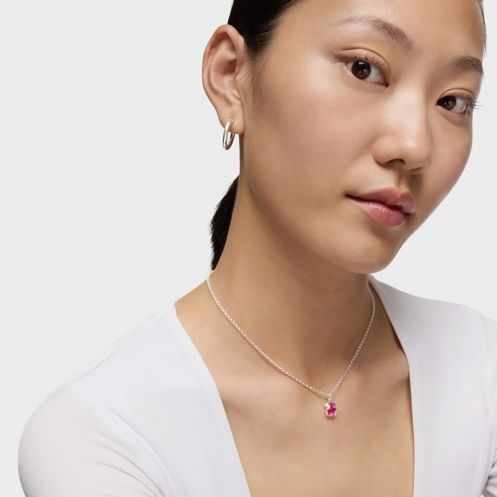 דוגמנית עונדת שרשרת כסף עם תליון ורוד ועגיל חישוק, תכשיטי CHOZEN, עיצוב יוקרתי