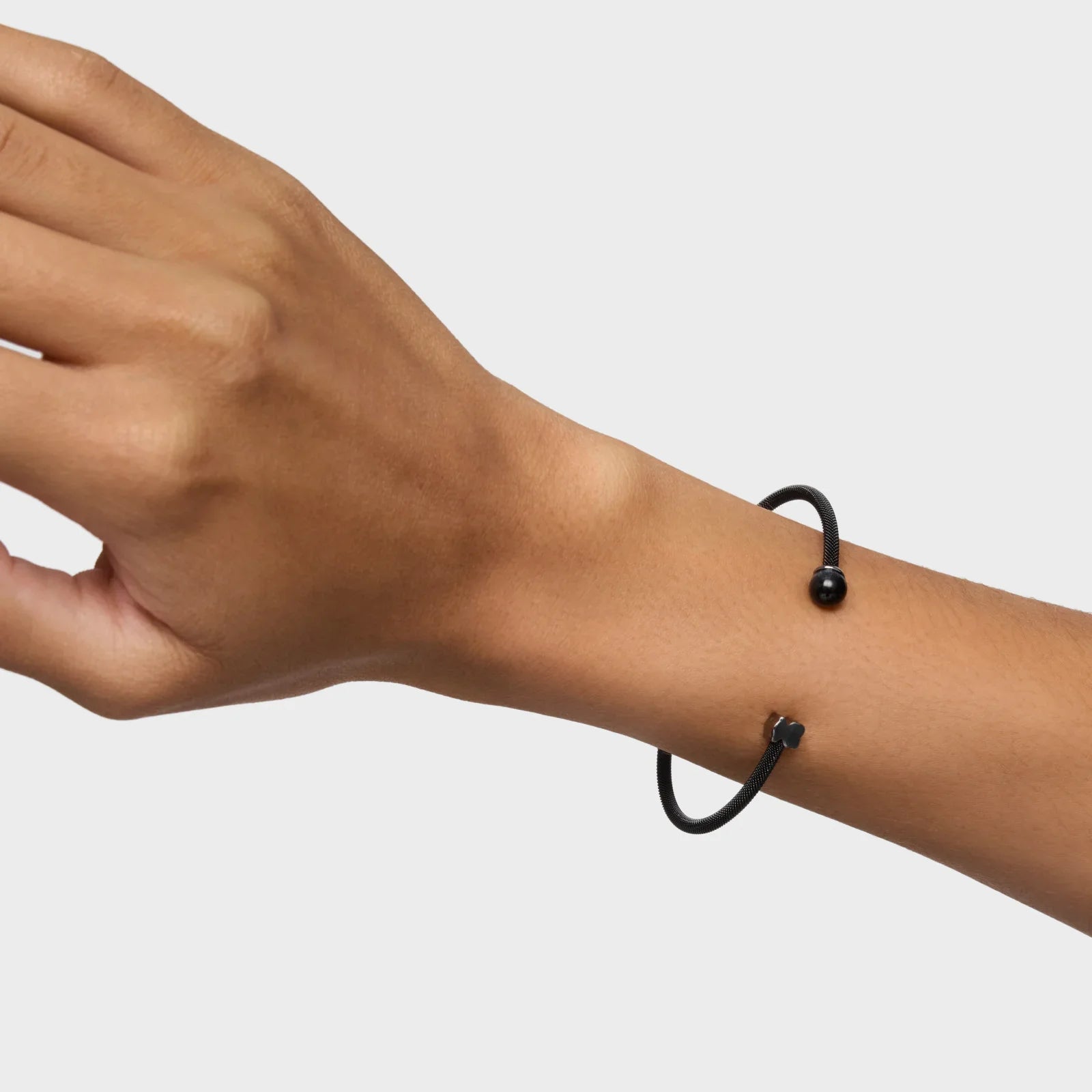 יד עם צמיד שחור יוקרתי, מותג CHOZEN, צילום רקע לבן, אופנה אלפא