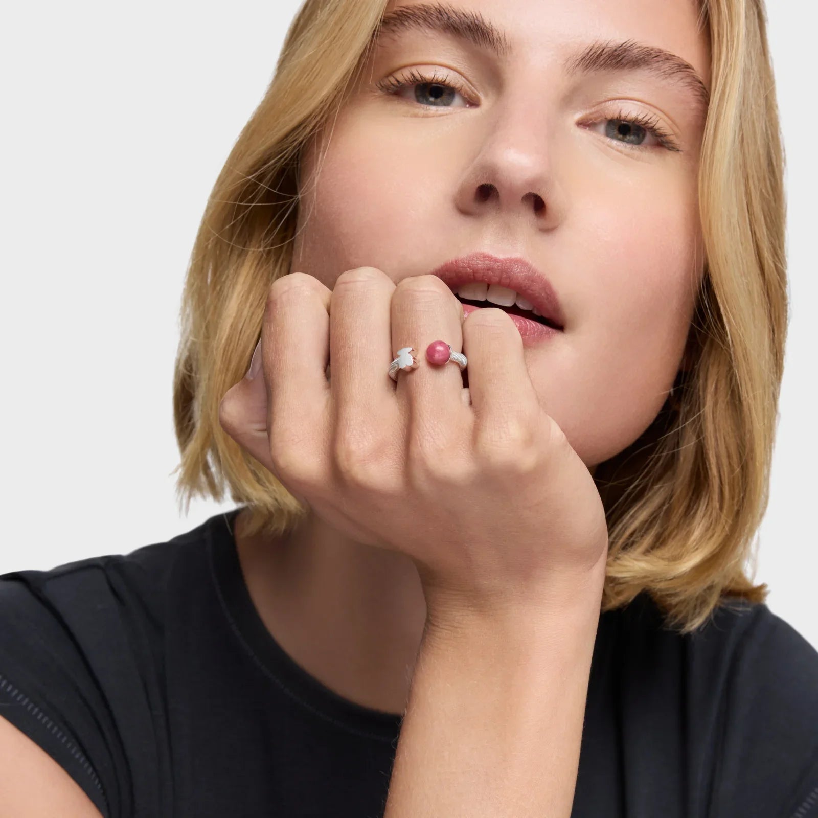 אישה עם שיער בלונדיני קצר עונדת טבעת עם אבן ורודה, תכשיט אופנה מבית CHOZEN