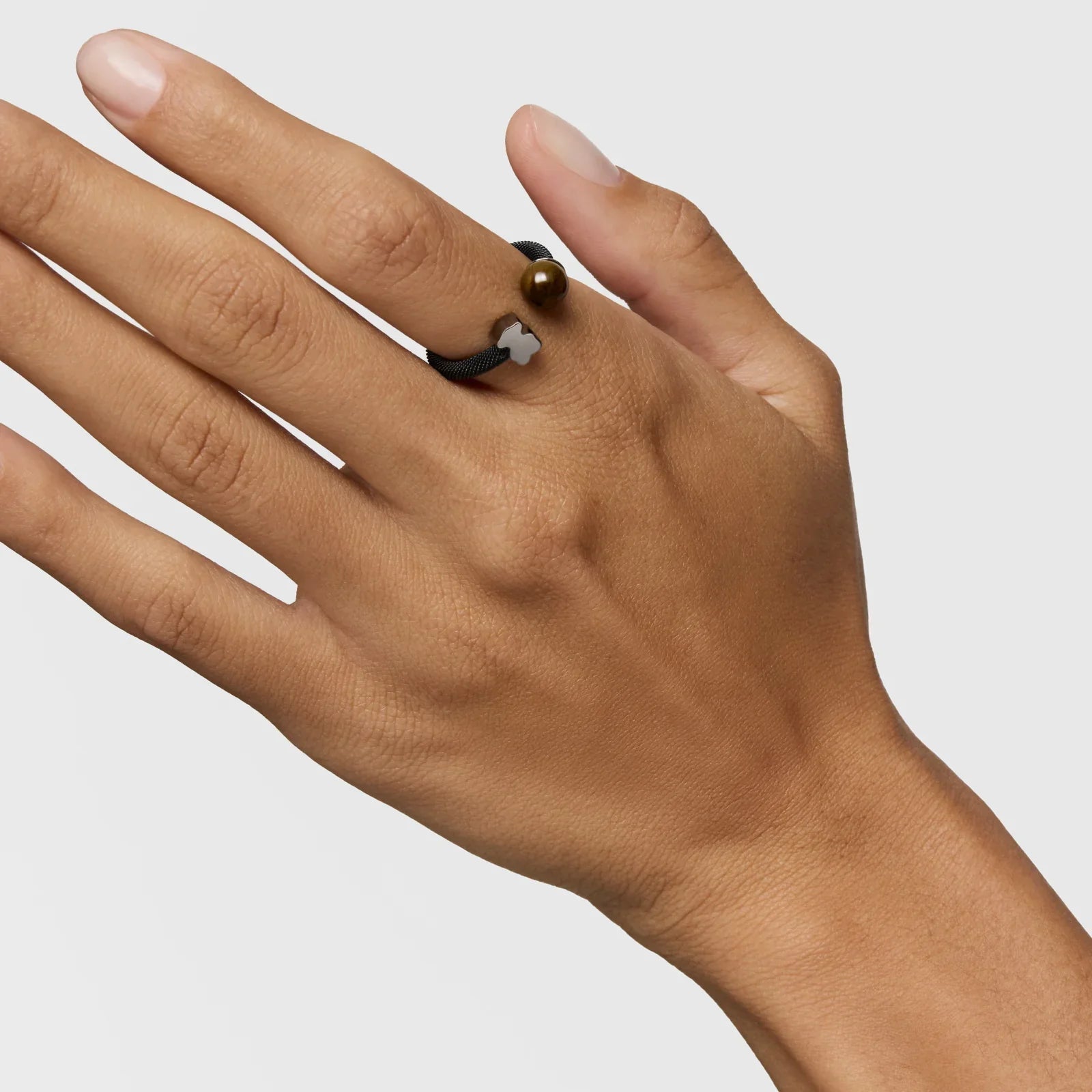 יד עונדת טבעת שחורה עם קישוט זהב ולבן, תכשיטים יוקרתיים CHOZEN