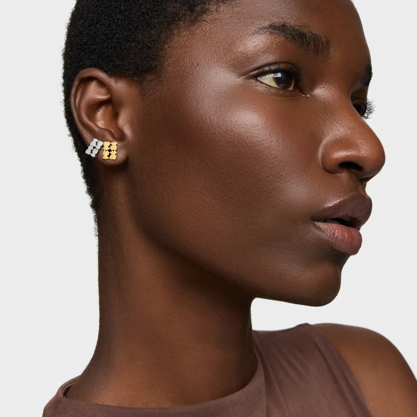 דוגמנית עונדת עגילים מעוצבים בזהב וכסף CHOZEN, תקריב אוזן על רקע לבן