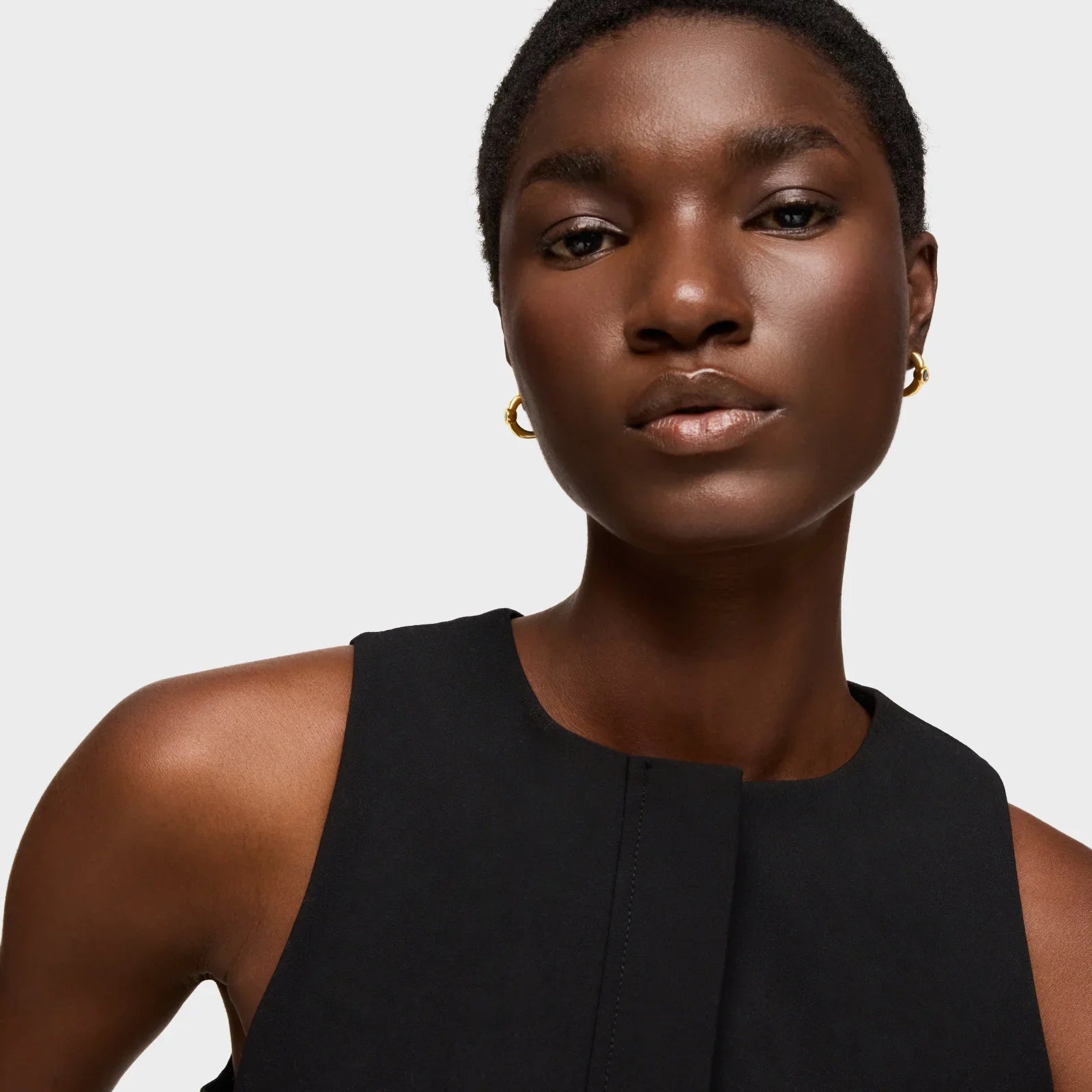 דוגמנית לובשת שמלת ערב שחורה ועגילי זהב, צילום מקצועי ל-CHOZEN