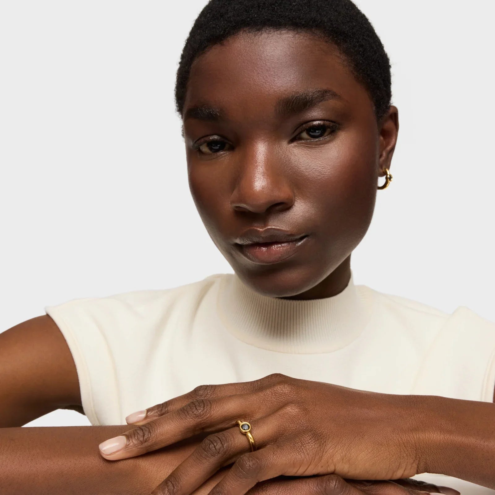 אישה עם עגיל זהב וטבעת מעוצבת, רקע לבן, קמפיין CHOZEN מותגים מובילים