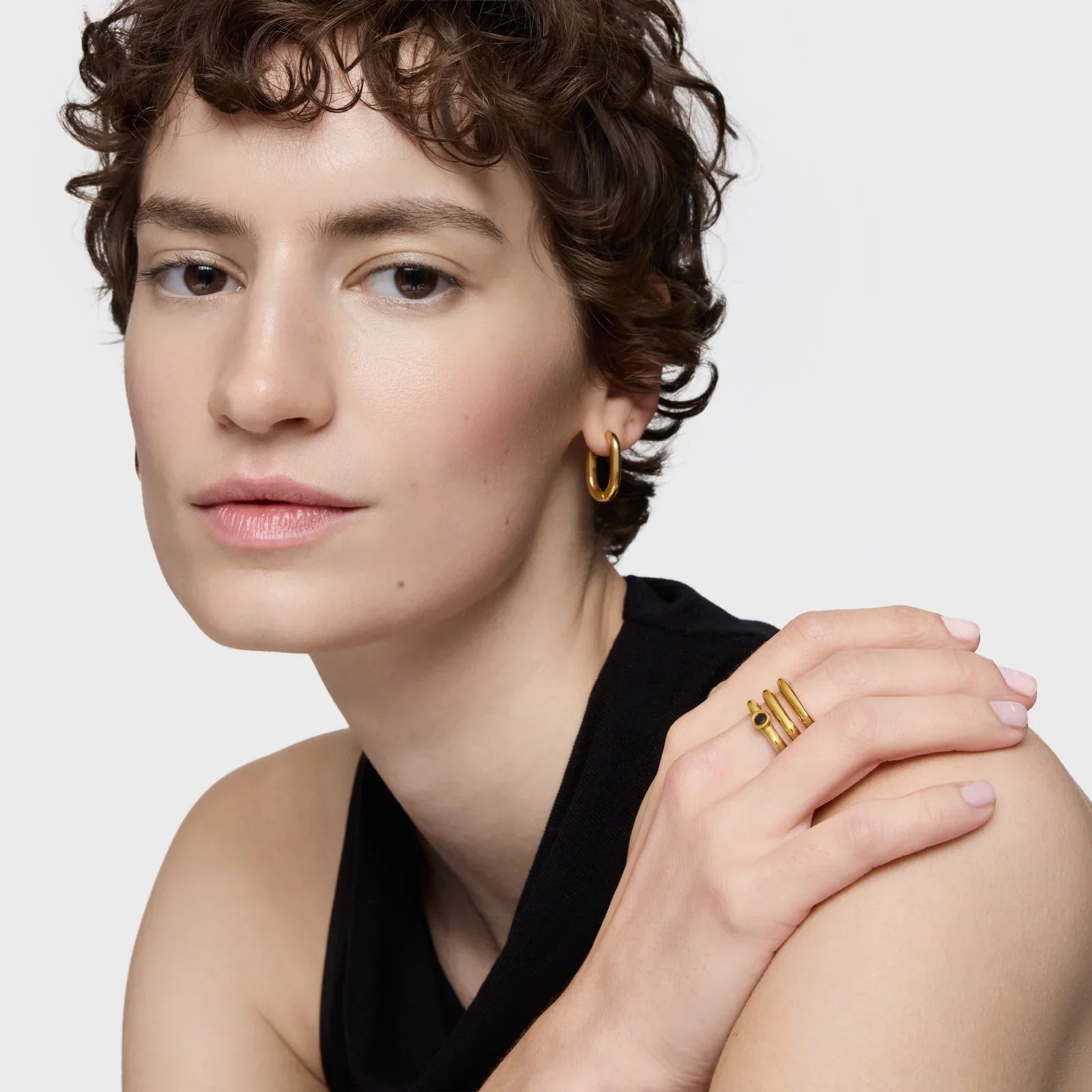 אישה עם שיער קצר עונדת עגיל זהב וטבעת זהב, תכשיטים אופנתיים מבית CHOZEN