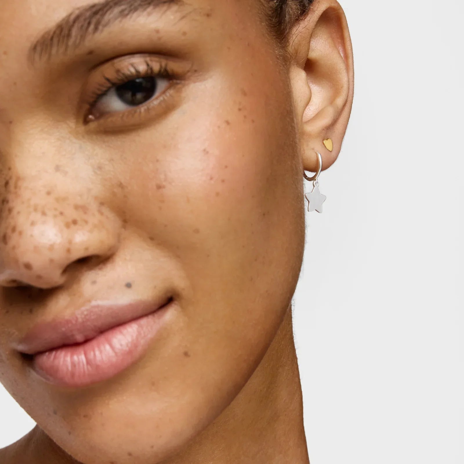 דוגמנית עם עגיל כסף בצורת כוכב ועגיל זהב קטן מהמותגים המובילים באתר CHOZEN