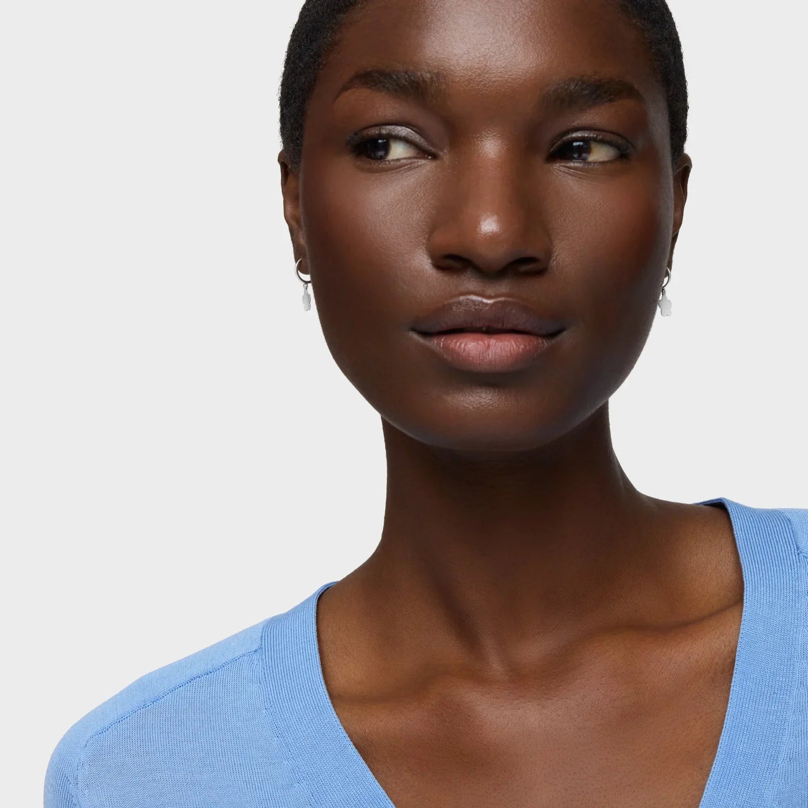 דוגמנית עם עגילים קטנים ולבושה בסוודר כחול, צילום תקריב, CHOZEN מותגים מובילים