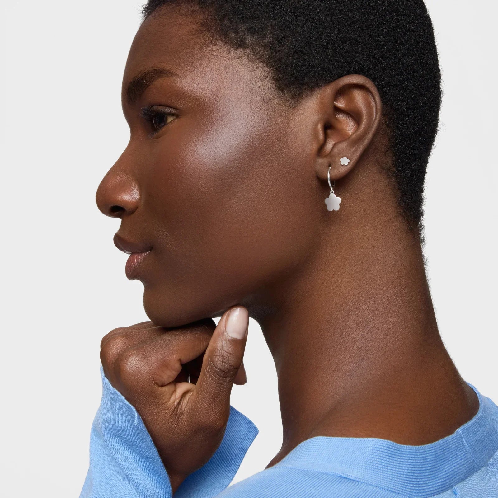 אישה עונדת עגילי פרח כסף, צילום אופנה תכשיטים CHOZEN, רקע לבן אלגנטי