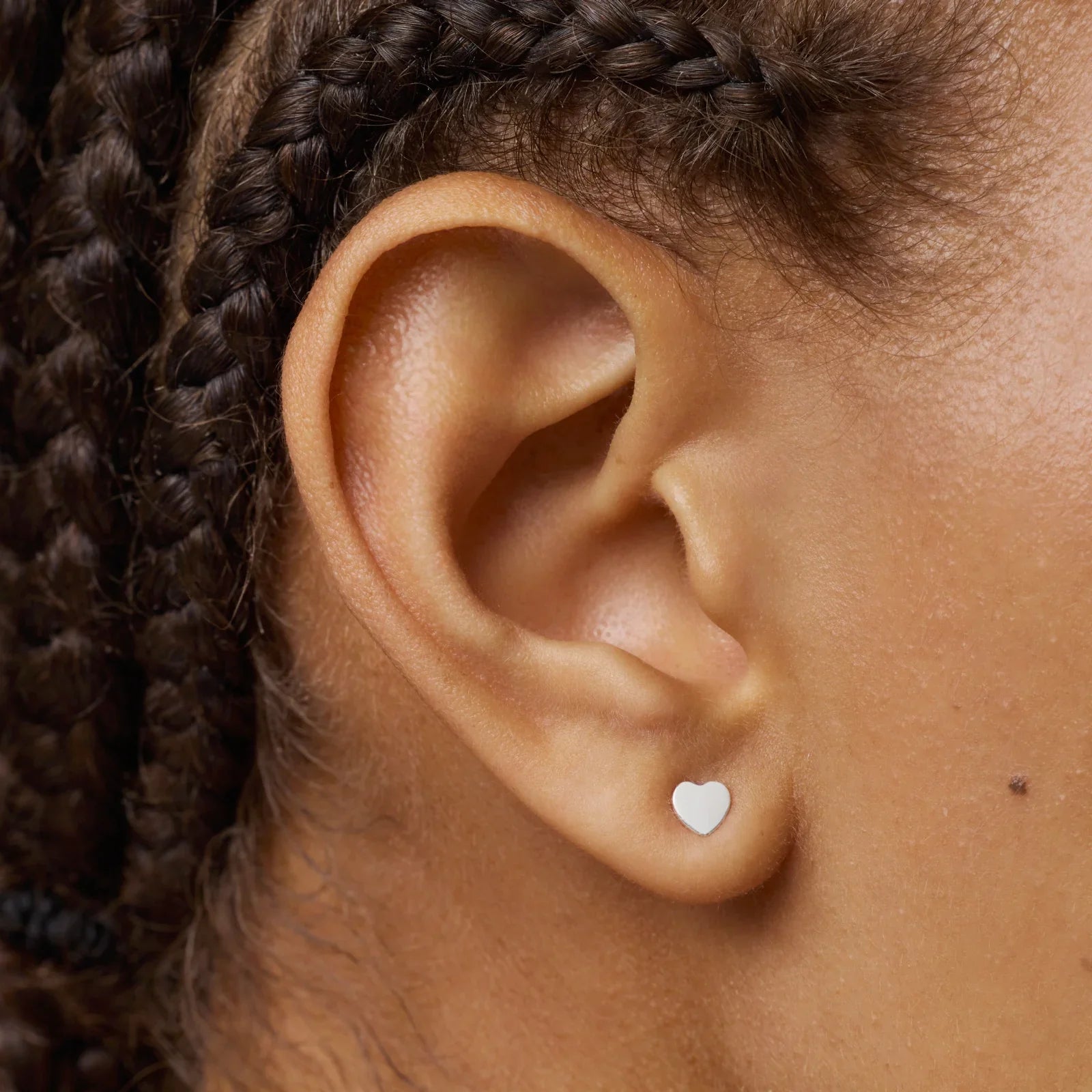 עגיל צמוד לאוזן בעיצוב לב, צילום תקריב עם צמות, מותג תכשיטים CHOZEN