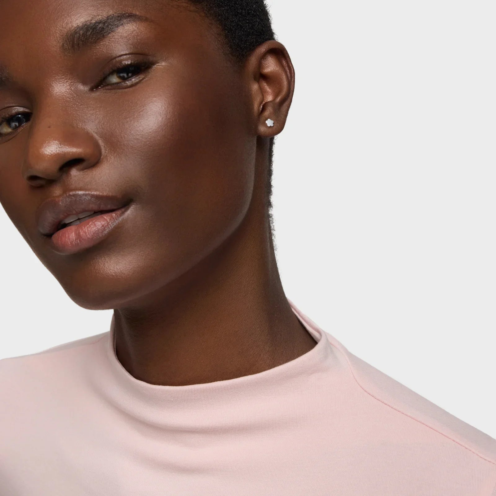 אישה עונדת עגיל יהלום עדין, חולצת טי ורודה, צילום אופנה איכותי לקבוצת אלפא CHOZEN