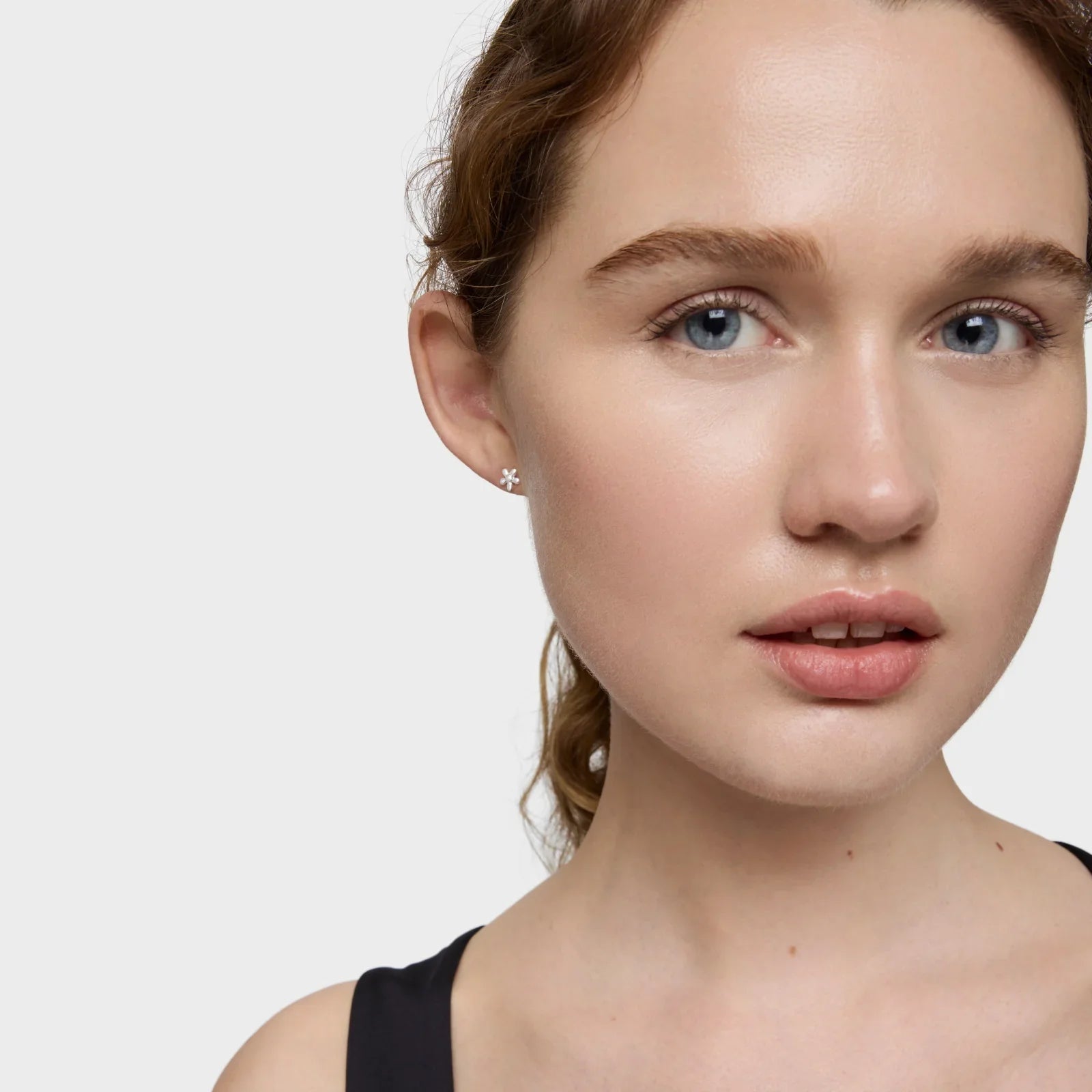 דוגמנית עונדת עגיל יהלום קטן מבית CHOZEN, רקע אחיד, אופנה תכשיטים יוקרתיים