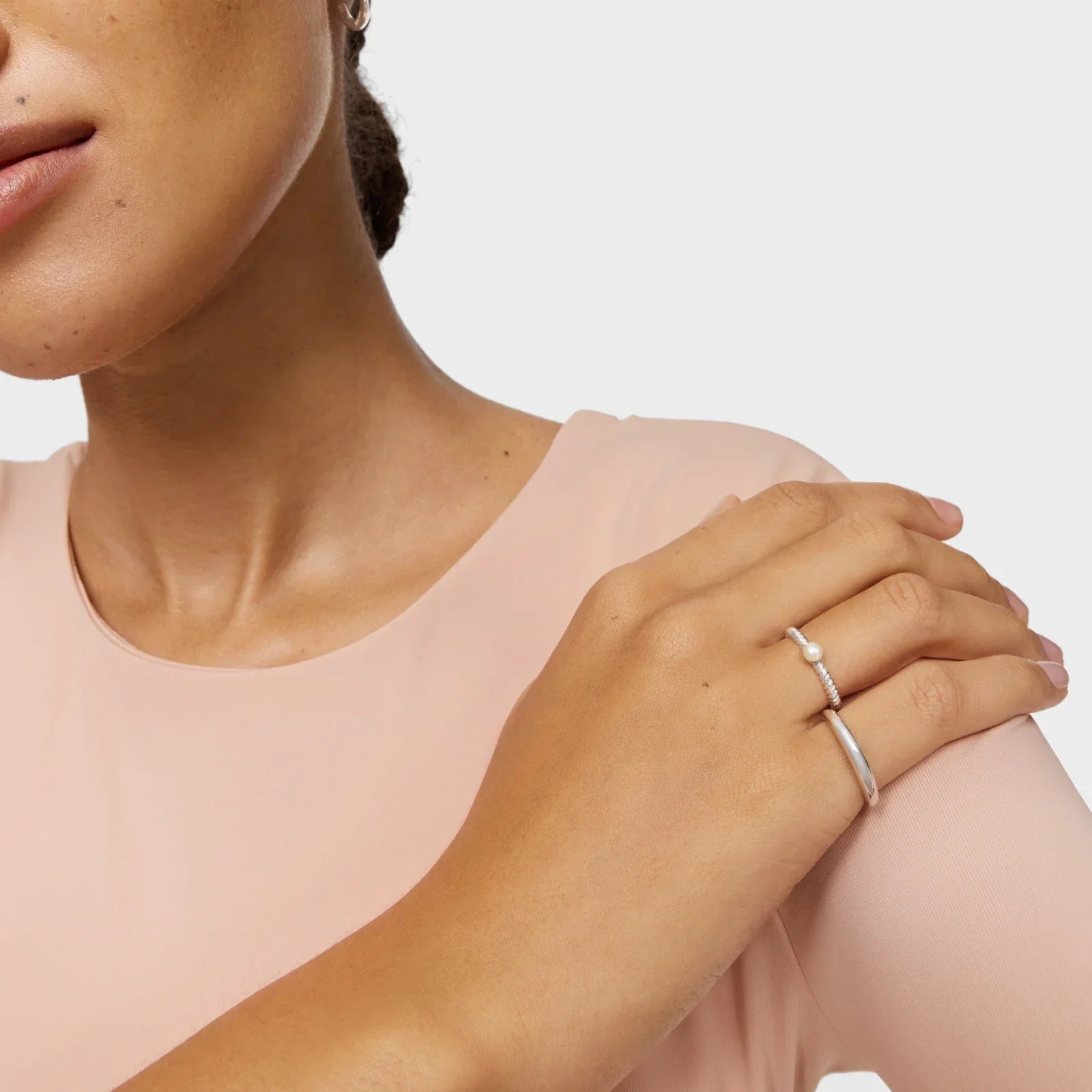 אישה עם שמלה ורודה עונדת טבעת כסף וגורמט עדין, תכשיטים יוקרתיים מקבוצת אלפא CHOZEN