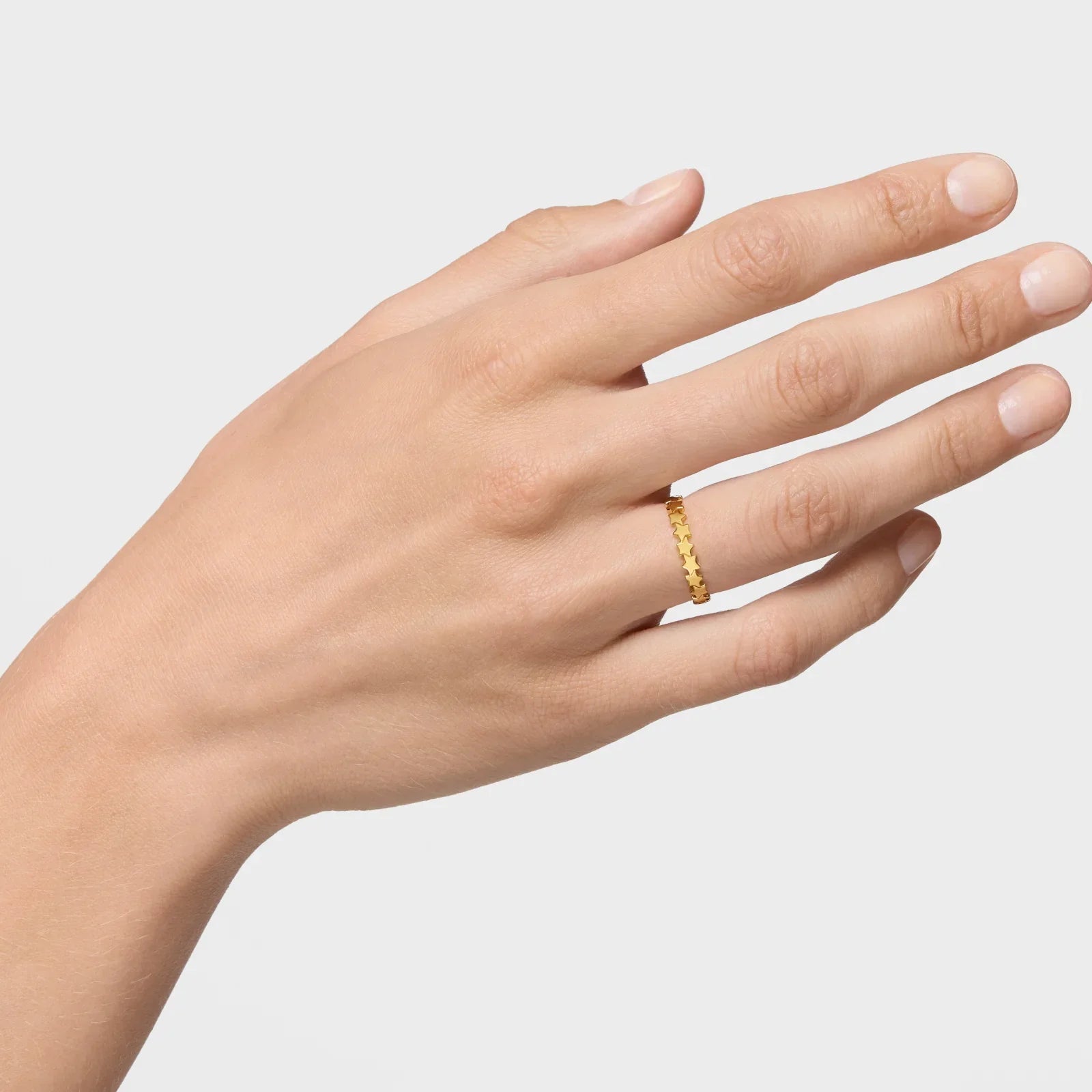 טבעת זהב דקה עם דוגמת כוכבים על אצבע, צילום מוצר של CHOZEN תכשיטים
